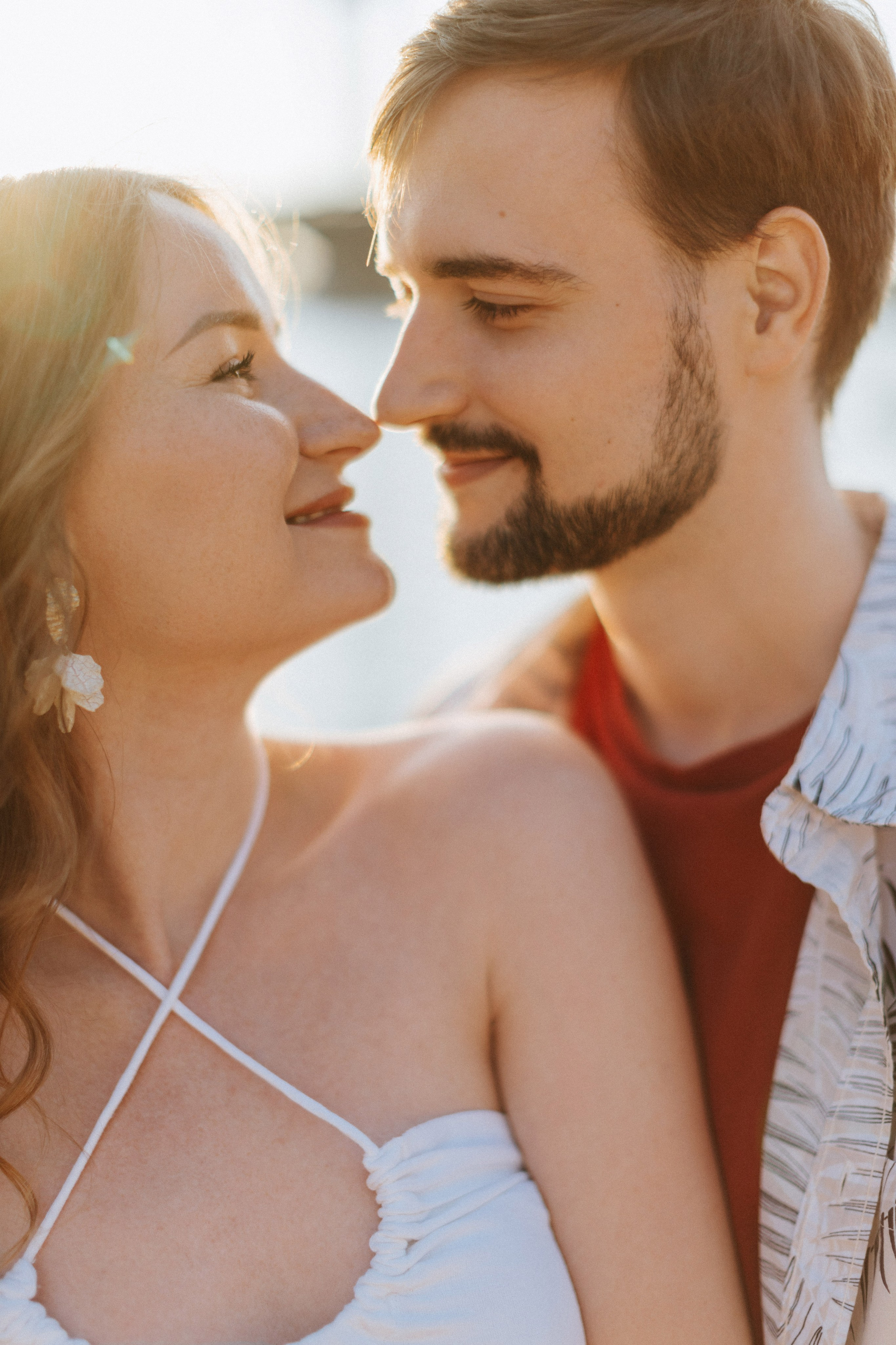 “Una coppia condivide un momento di tenerezza con la donna che tiene le foto dell'ecografia sulla schiena dell'uomo. La coppia si trova all'aperto e la luce del sole splende dolcemente su di loro”.