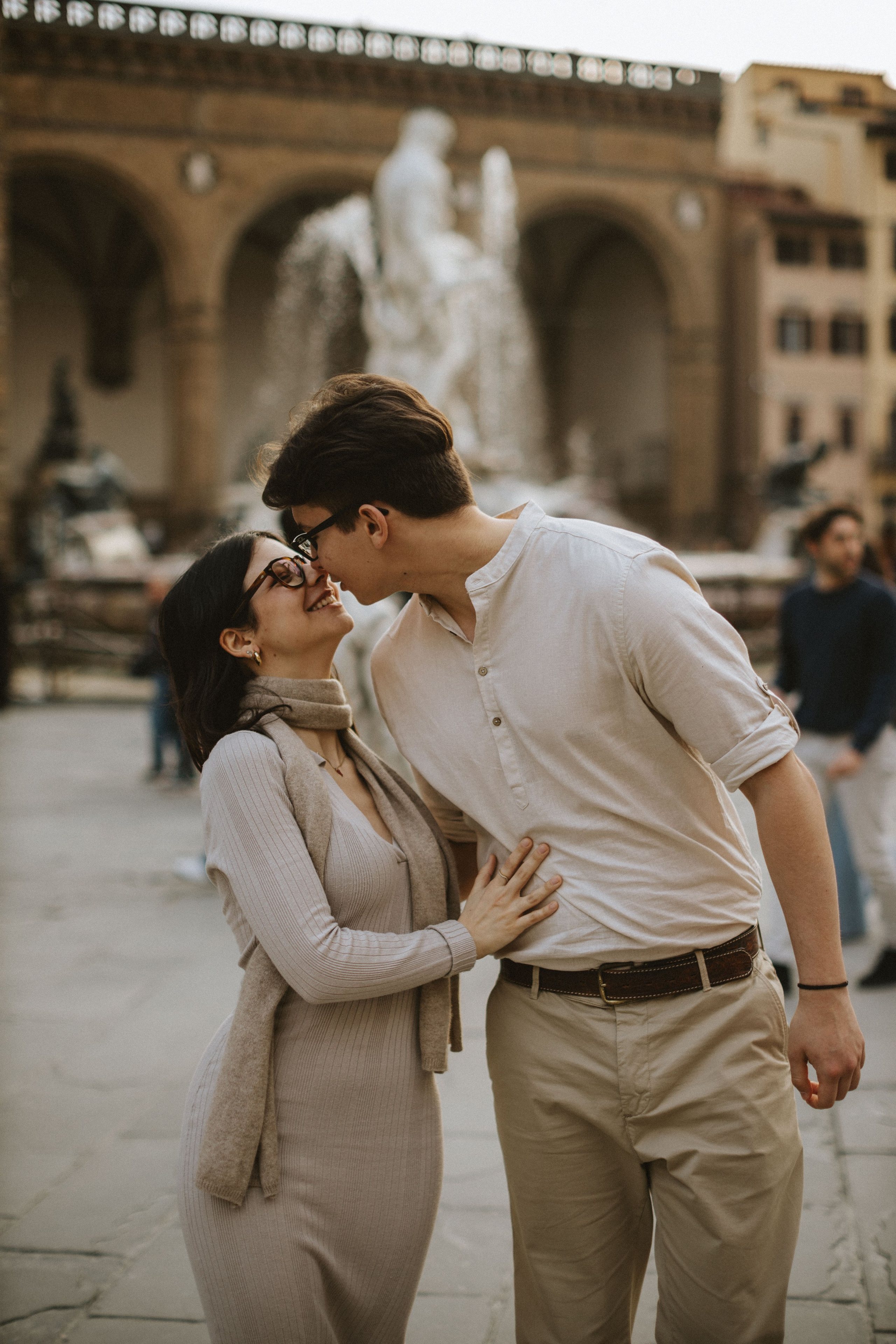 “Una coppia gioiosa che condivide un momento davanti alla famosa fontana, irradiando felicità”.