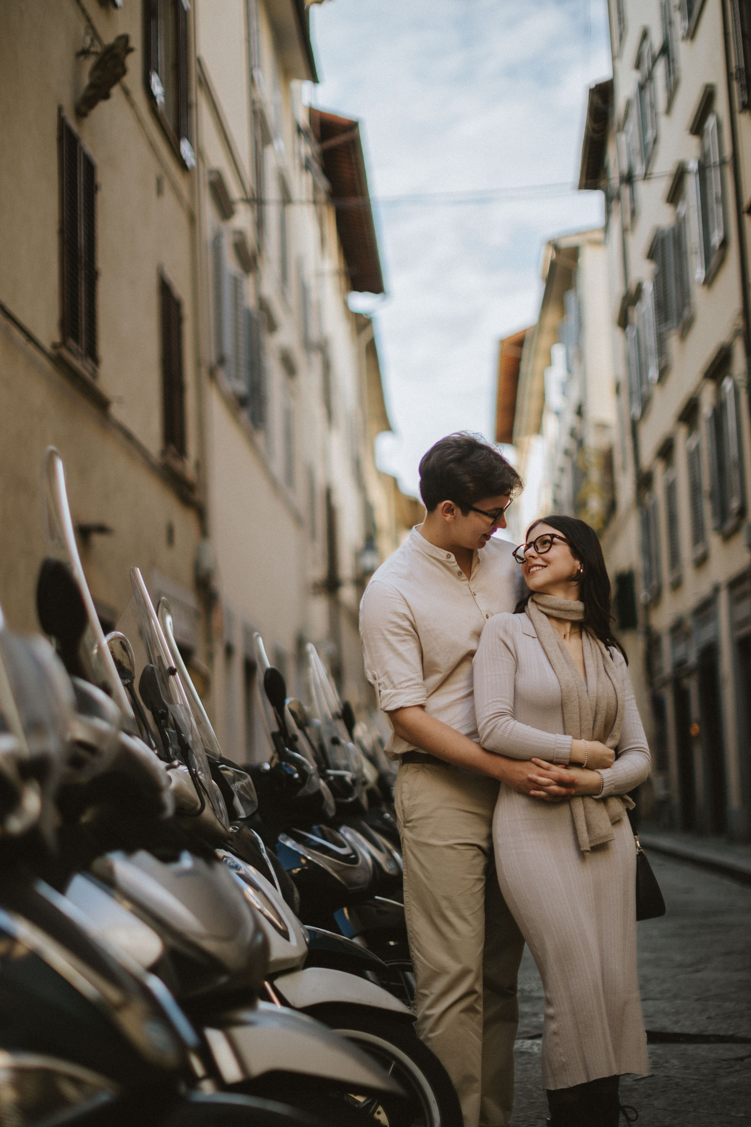 “Una coppia che si abbraccia in una strada di Firenze, circondata da scooter”.