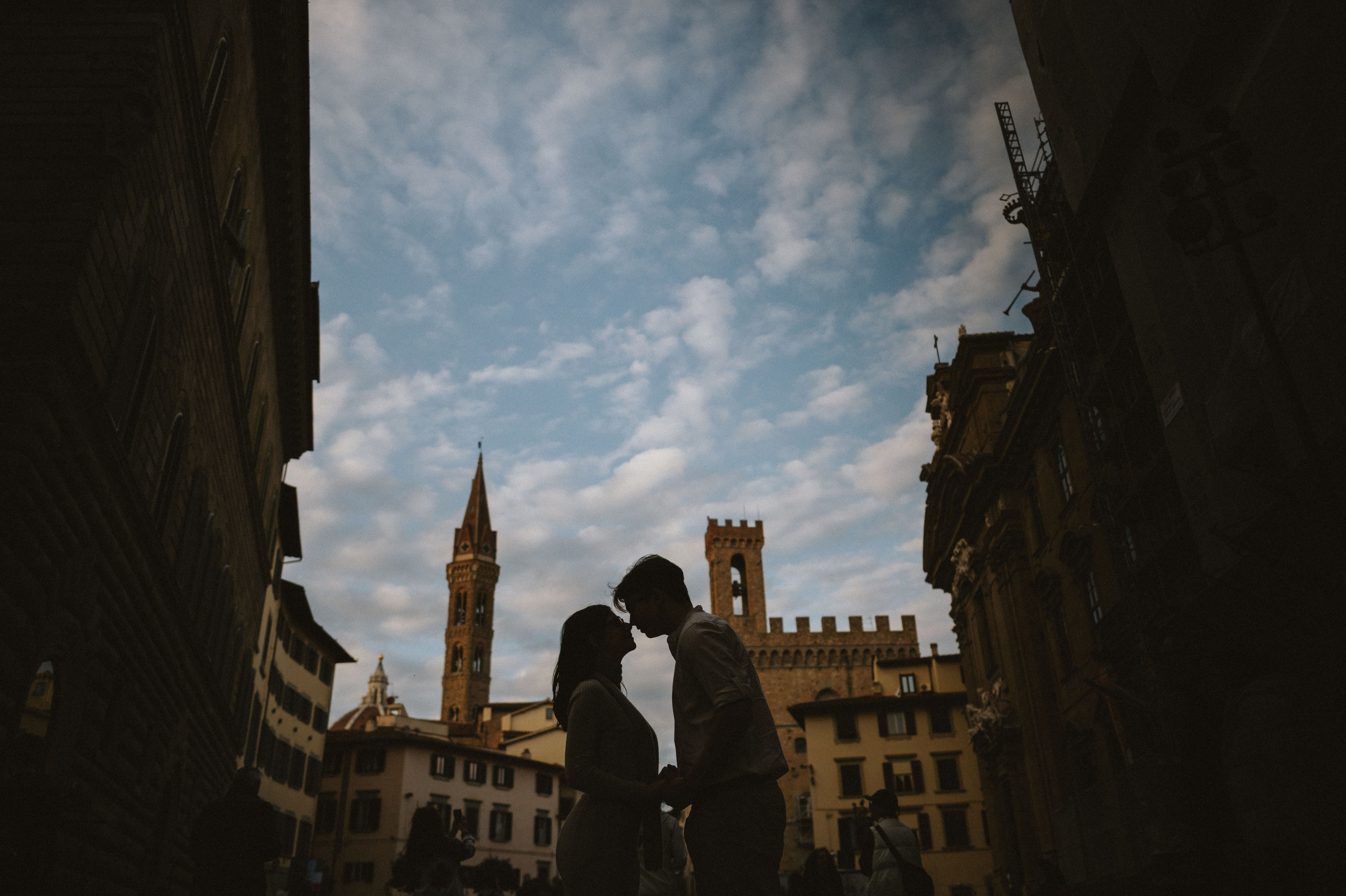 “Silhouette di una coppia che condivide un momento di tenerezza sullo sfondo dell'architettura storica di Firenze”.