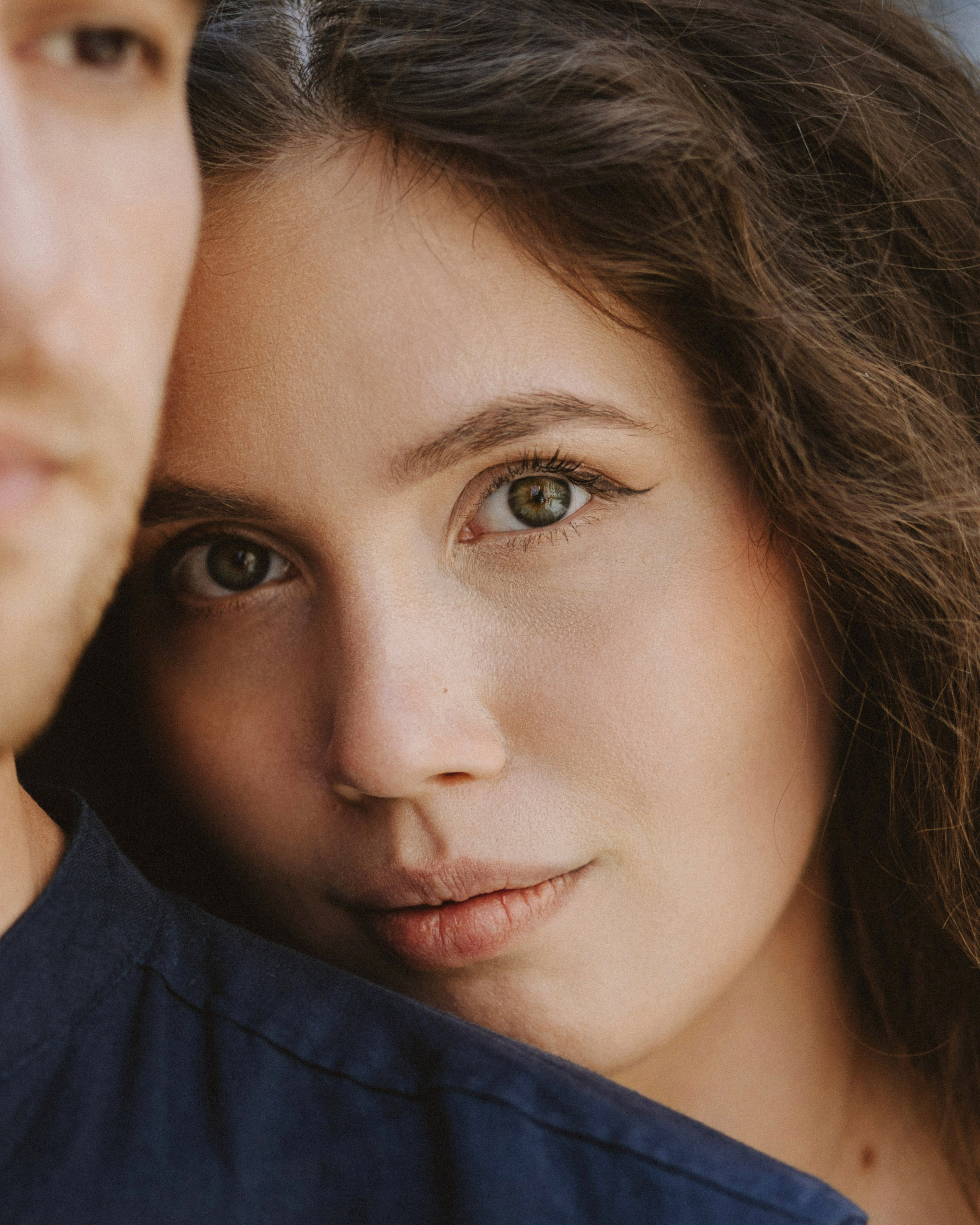 “Portrait of the bride in Tuscany, gently looking at the camera while being close to the groom, with soft makeup and a natural expression.”