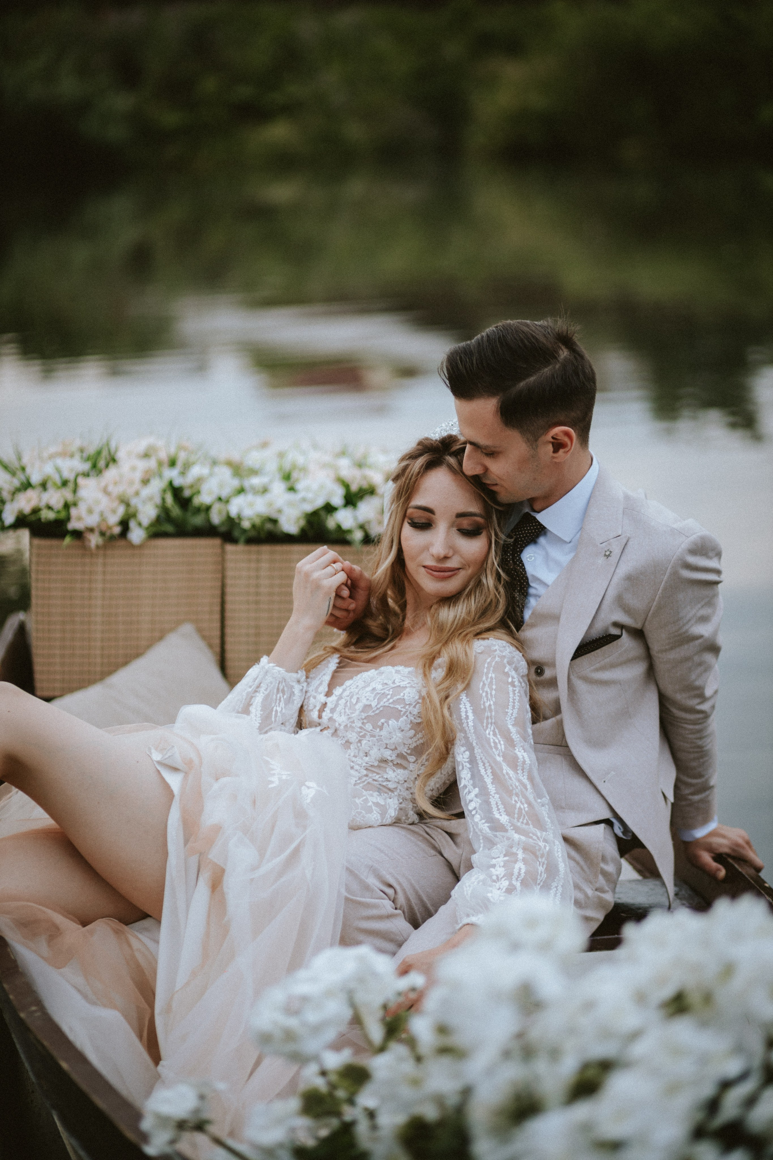 Couple embracing in rowboat surrounded by calm water and floral details