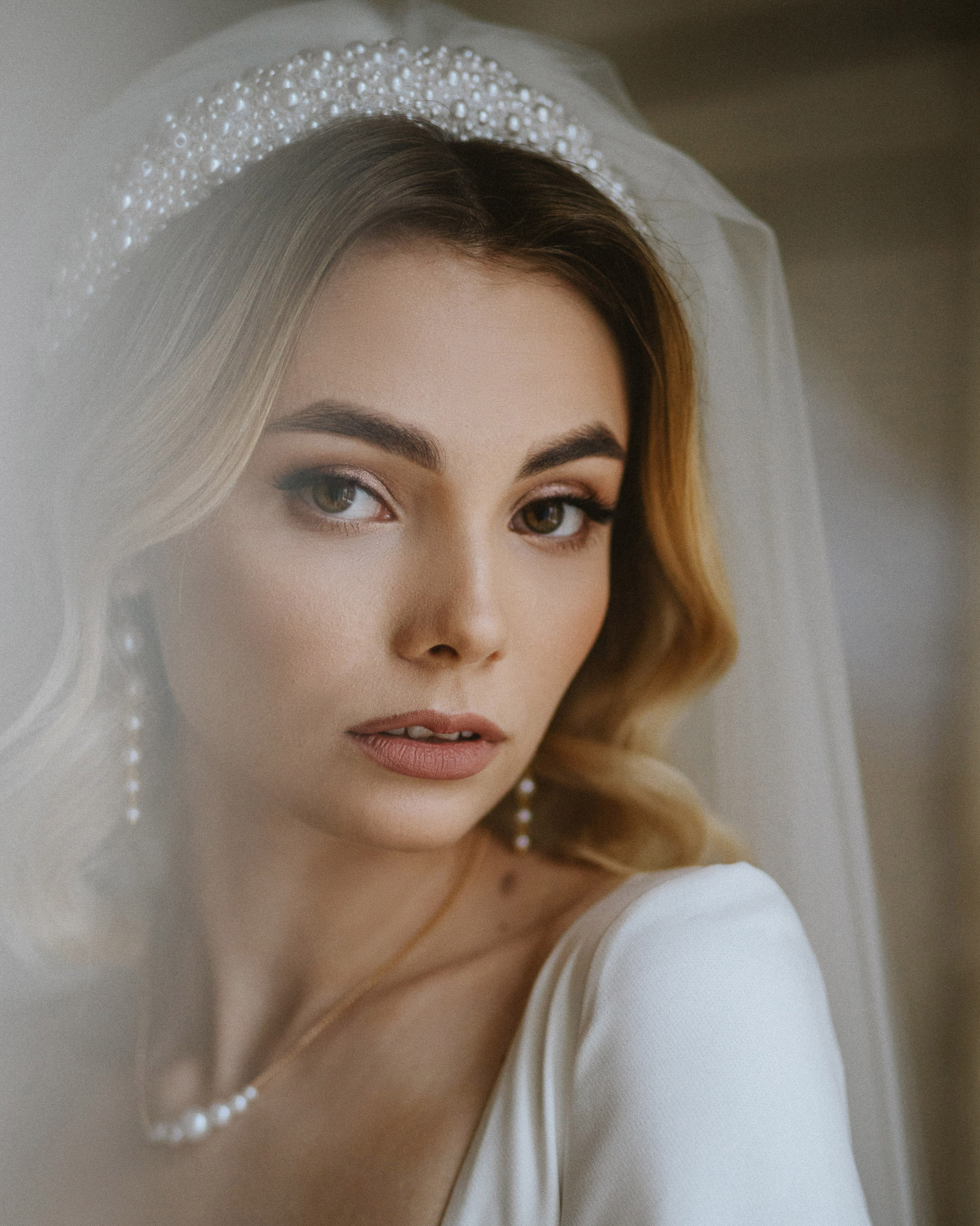 "Bridal portrait, beautiful bride with pearl headband and veil."