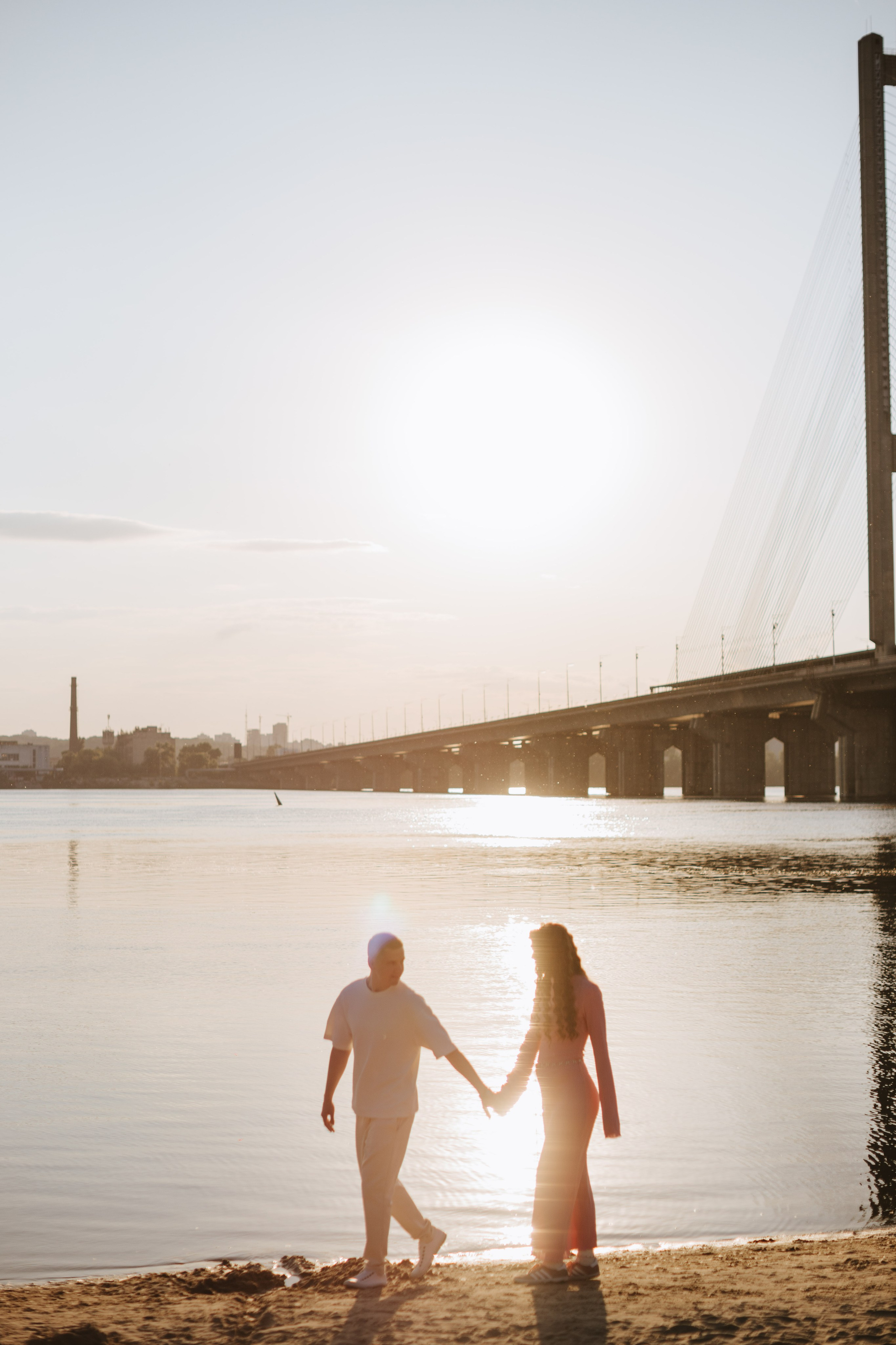 “Un gioioso momento familiare in cui una madre, un padre e la loro bambina ridono e giocano in un prato soleggiato. La bambina indossa un grazioso vestitino bianco con un fiocco in testa e i genitori sono impegnati nel momento, sorridendo”.