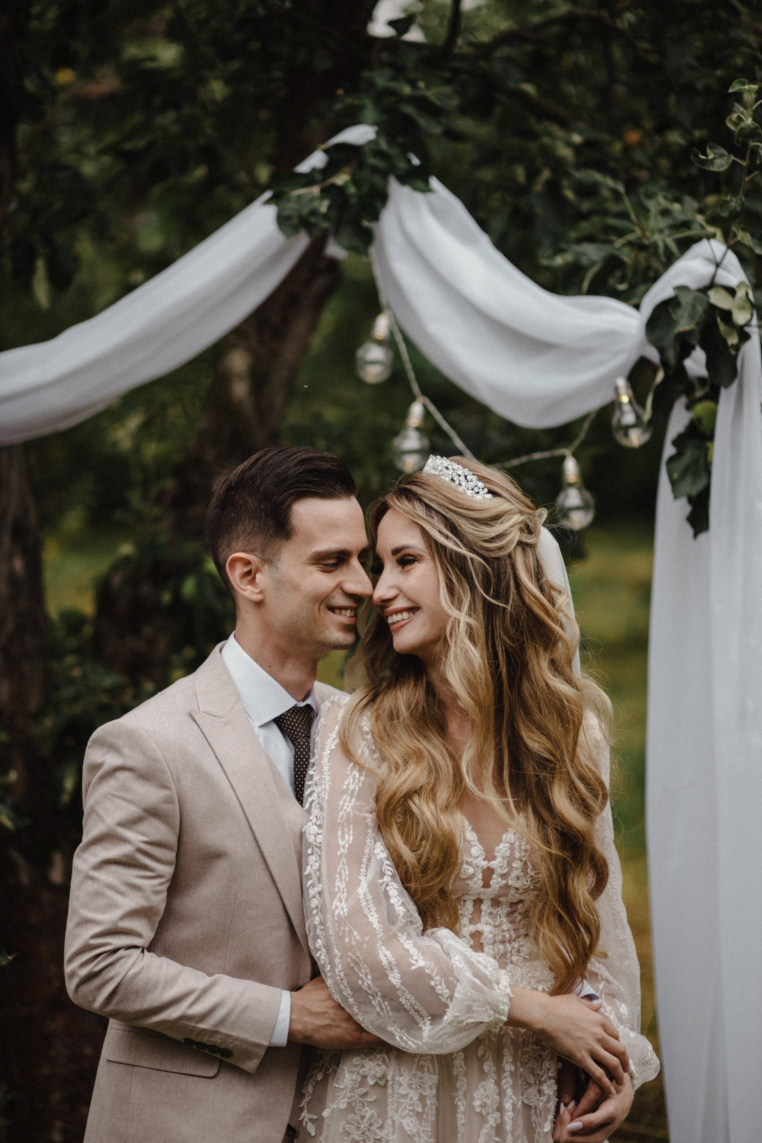 Bride and groom smiling in vintage-inspired setting with soft natural light