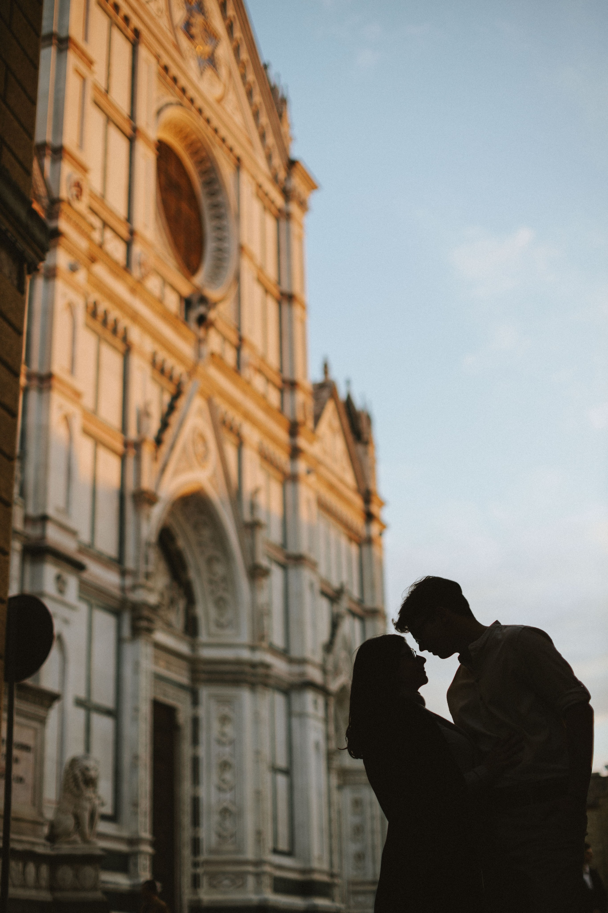 “Una coppia che si bacia davanti a una bella chiesa durante il tramonto, creando una silhouette romantica”.