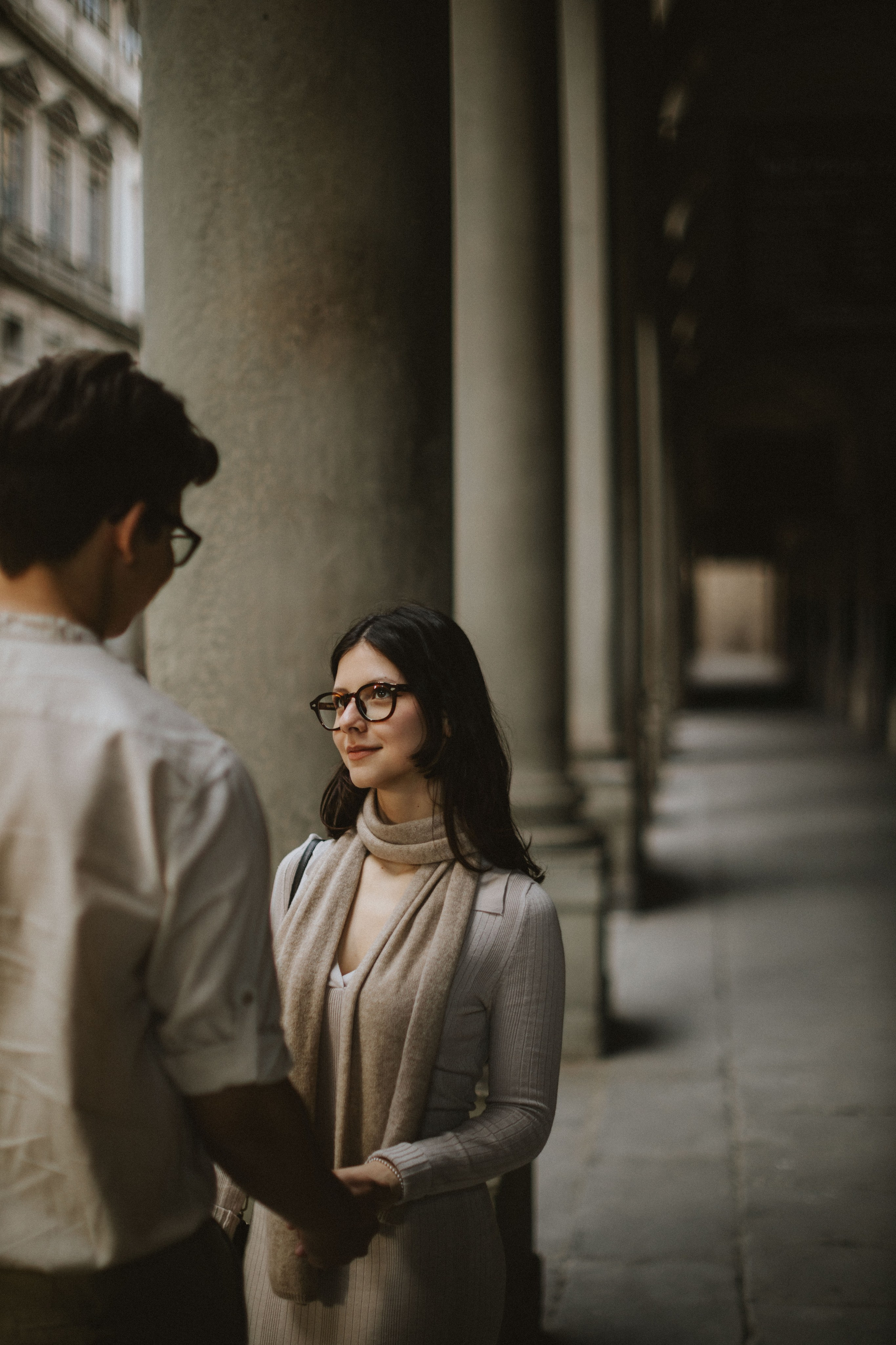 “Una coppia che condivide un momento di tranquillità e intimità sotto gli archi, circondata dalla storia”.