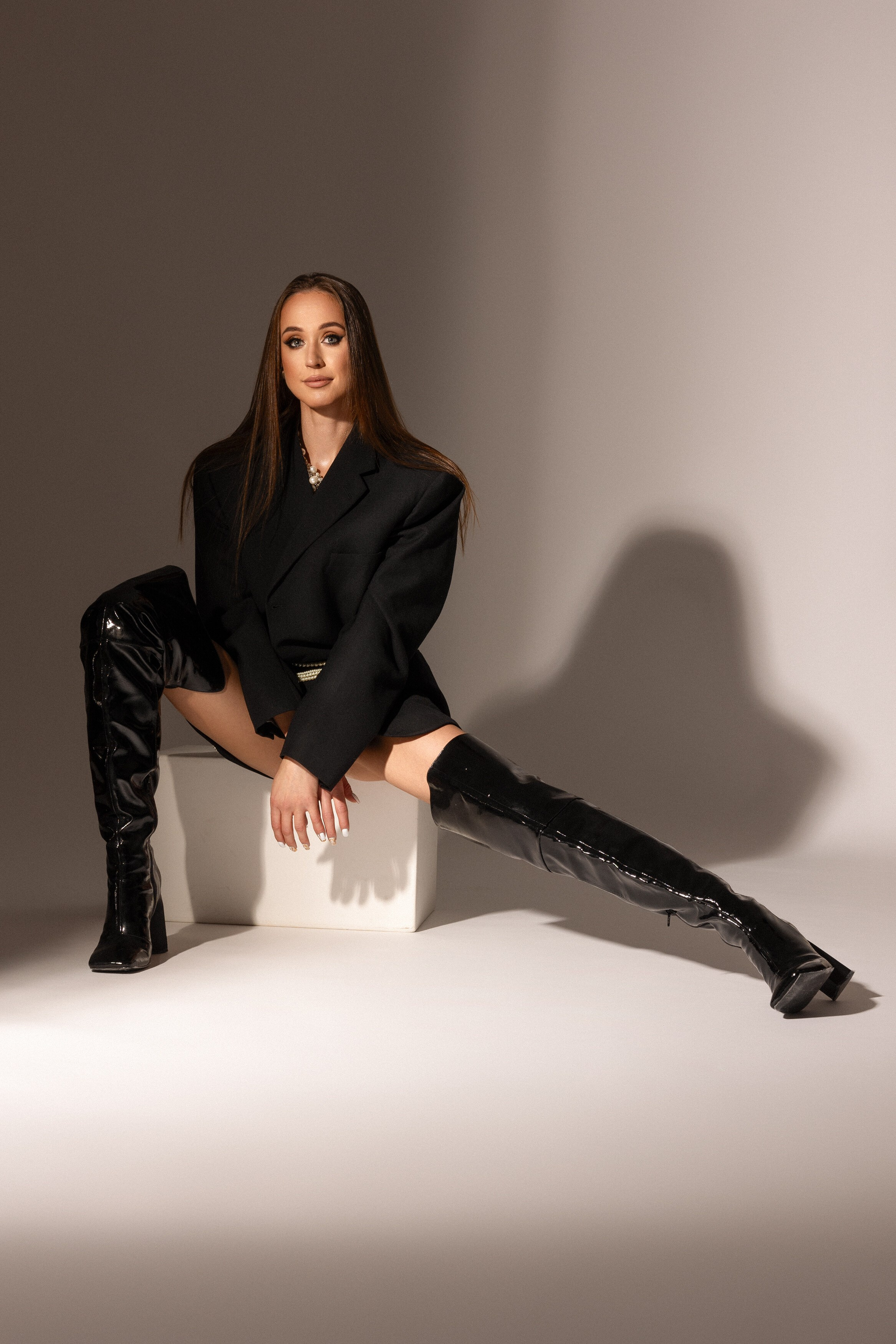 alt="kobieta w minimalistycznej czarnej stylizacji z marynarką – sesja zdjęciowa zmysłowa i elegancka"