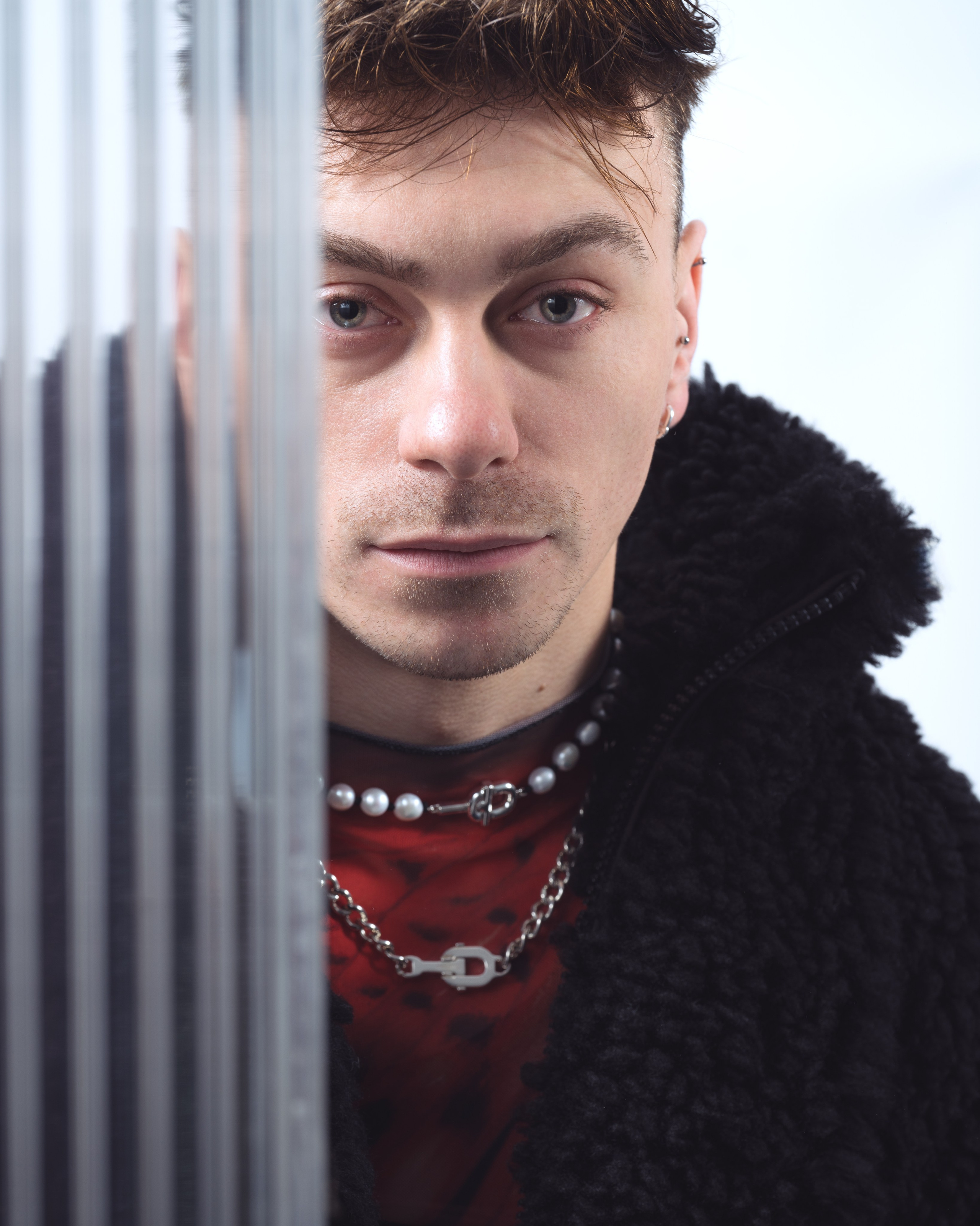 alt="model w eleganckiej męskiej stylizacji z naszyjnikiem TOUS – modowa sesja zdjęciowa"