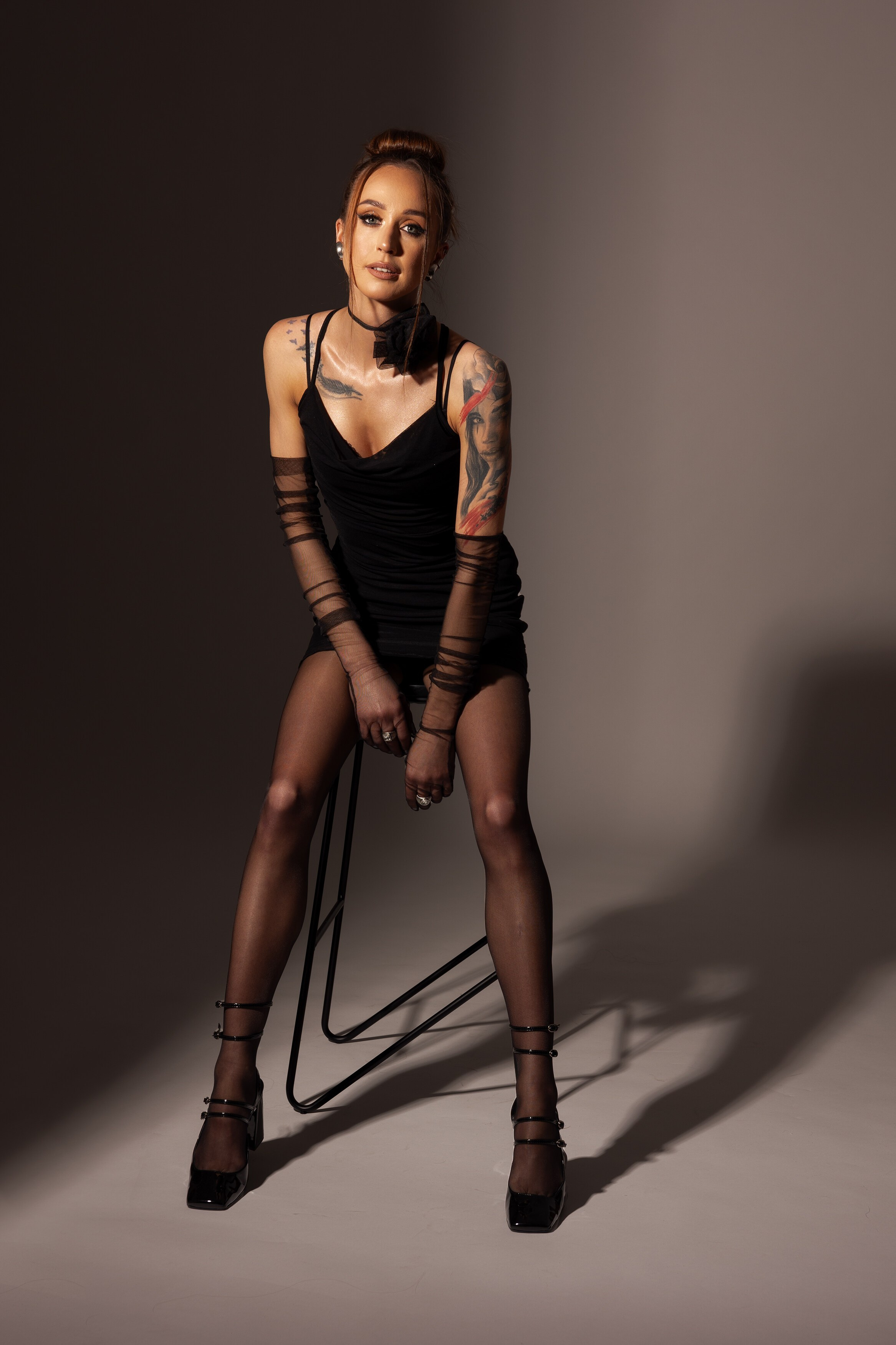 alt="modowa sesja zdjęciowa dla kobiety – minimalistyczna stylizacja w czerni z mocnym akcentem"