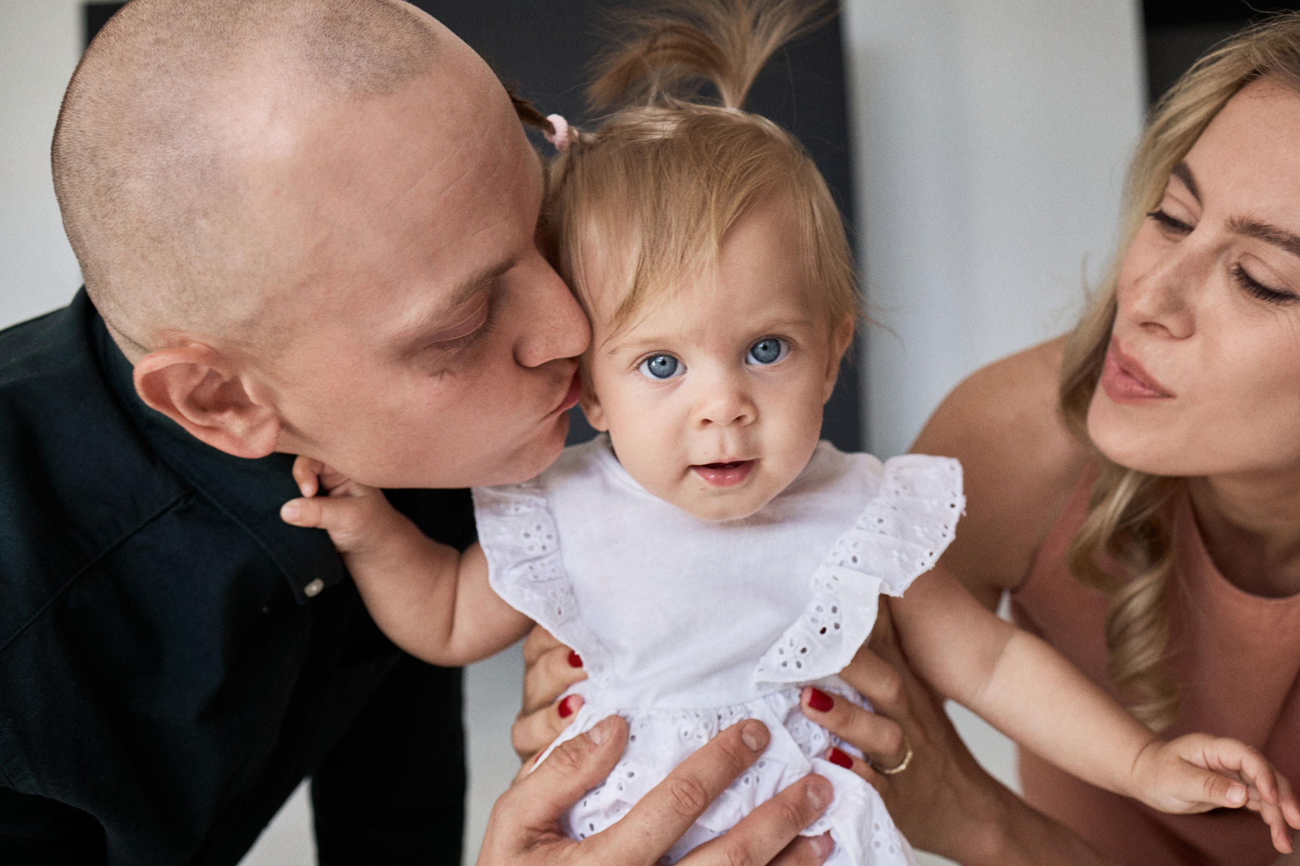 Ніжний момент з дитиною — батьки цілують доньку, студія, фотограф у Дніпрі