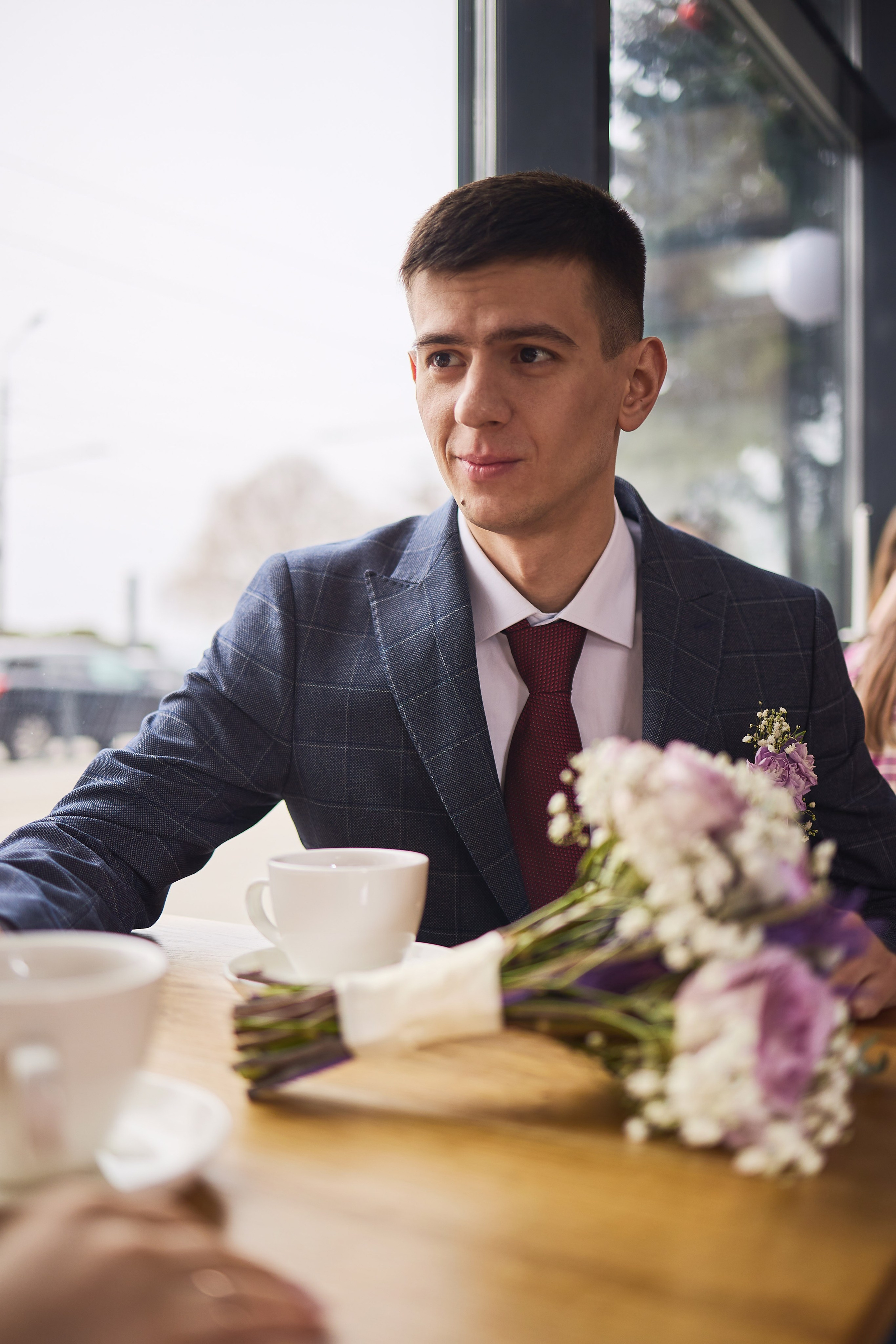 Весільний портрет у закладі — наречений у костюмі біля вікна