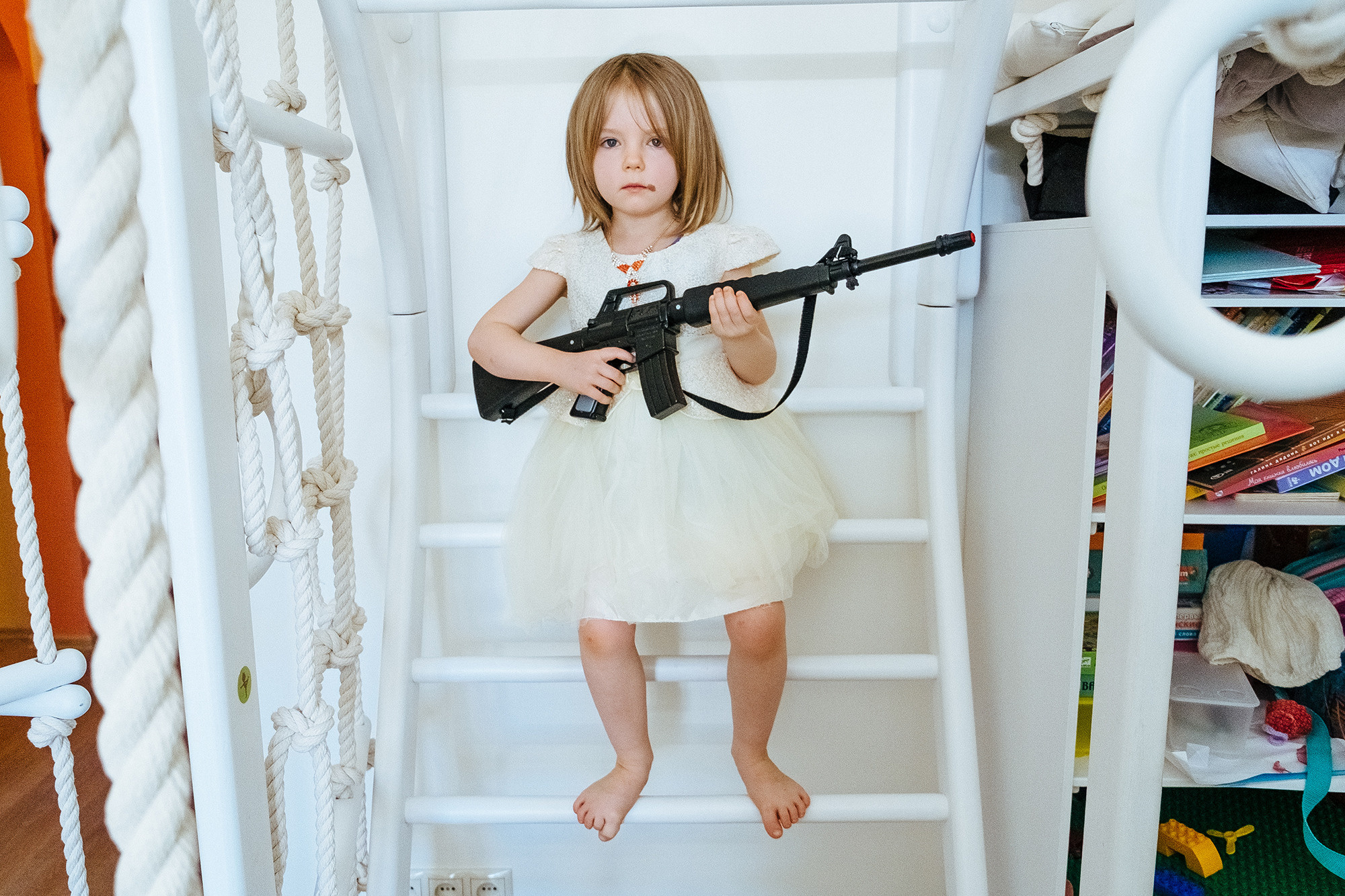 A girl in a white dress with a gun. Девочка в белом платье с ружьем.