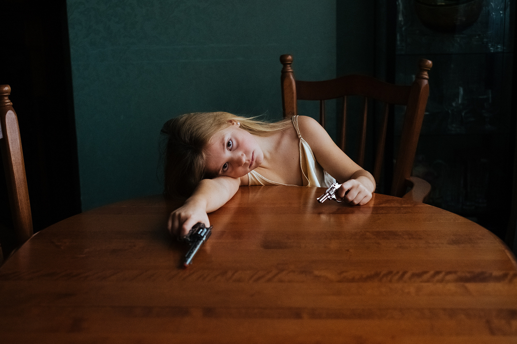 The girl is holding two pistols. Девочка держит два пистолета.