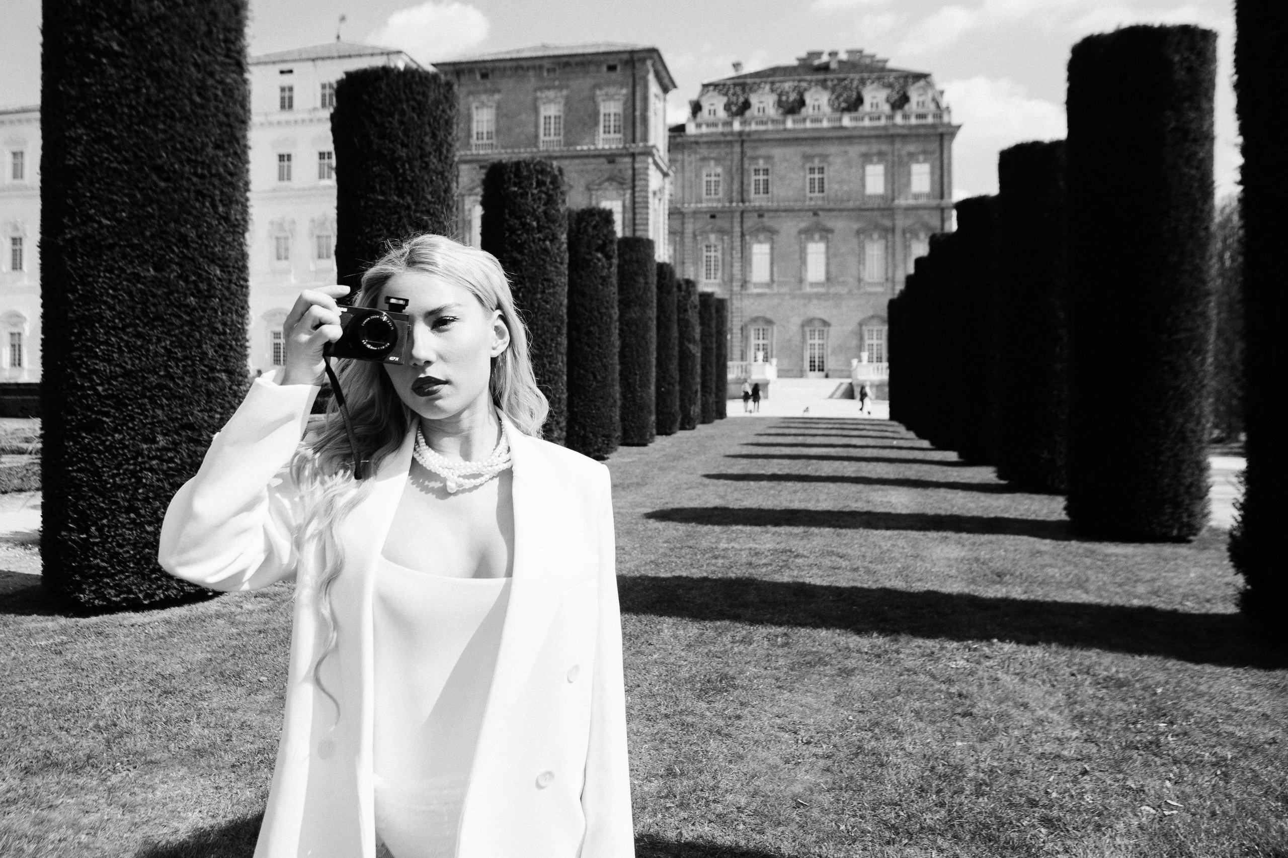 Bride holding a photo camera in a creative, stylized portrait, in Italian style