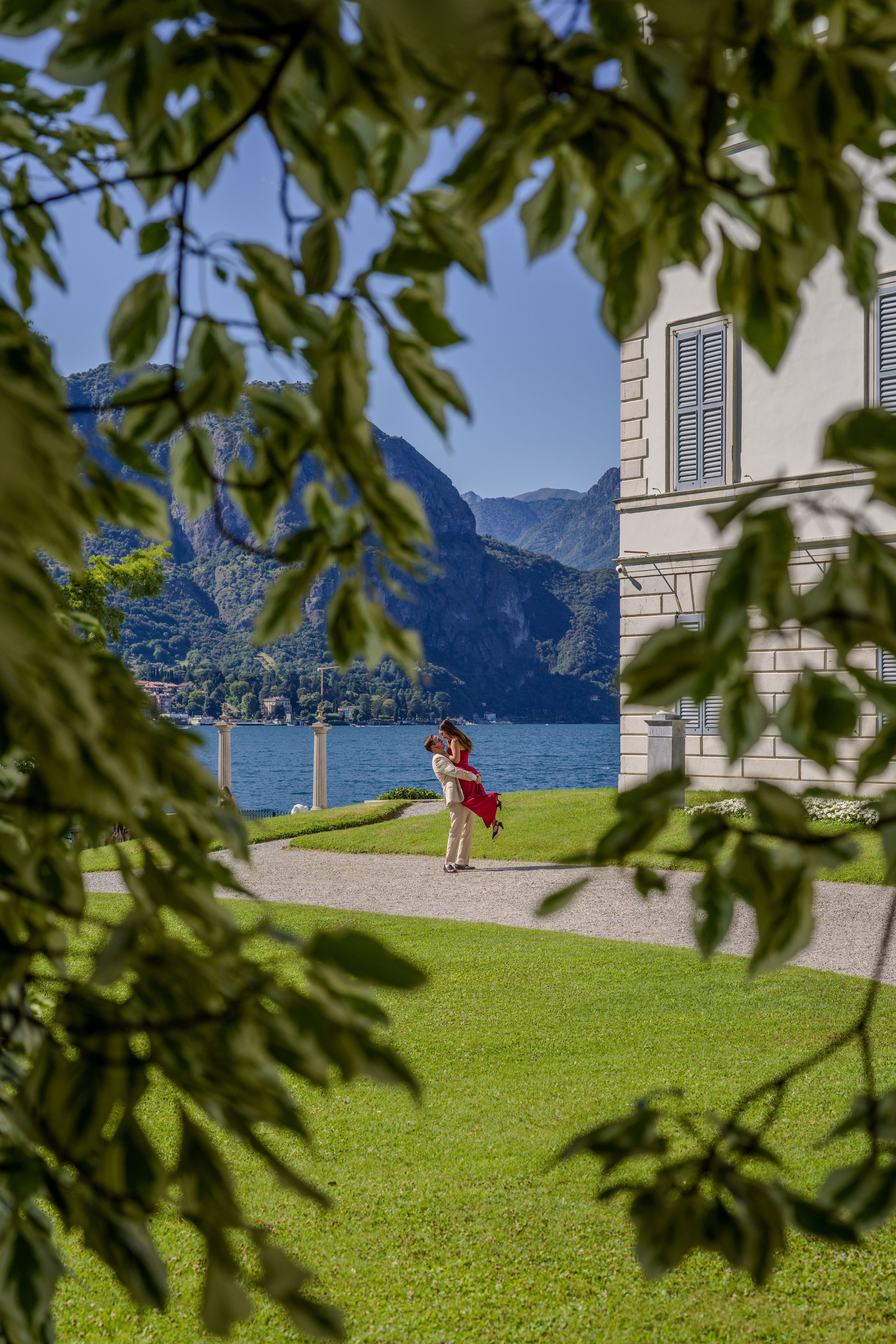 Engaged couple walking through historic Villa Melzi garden after proposal.