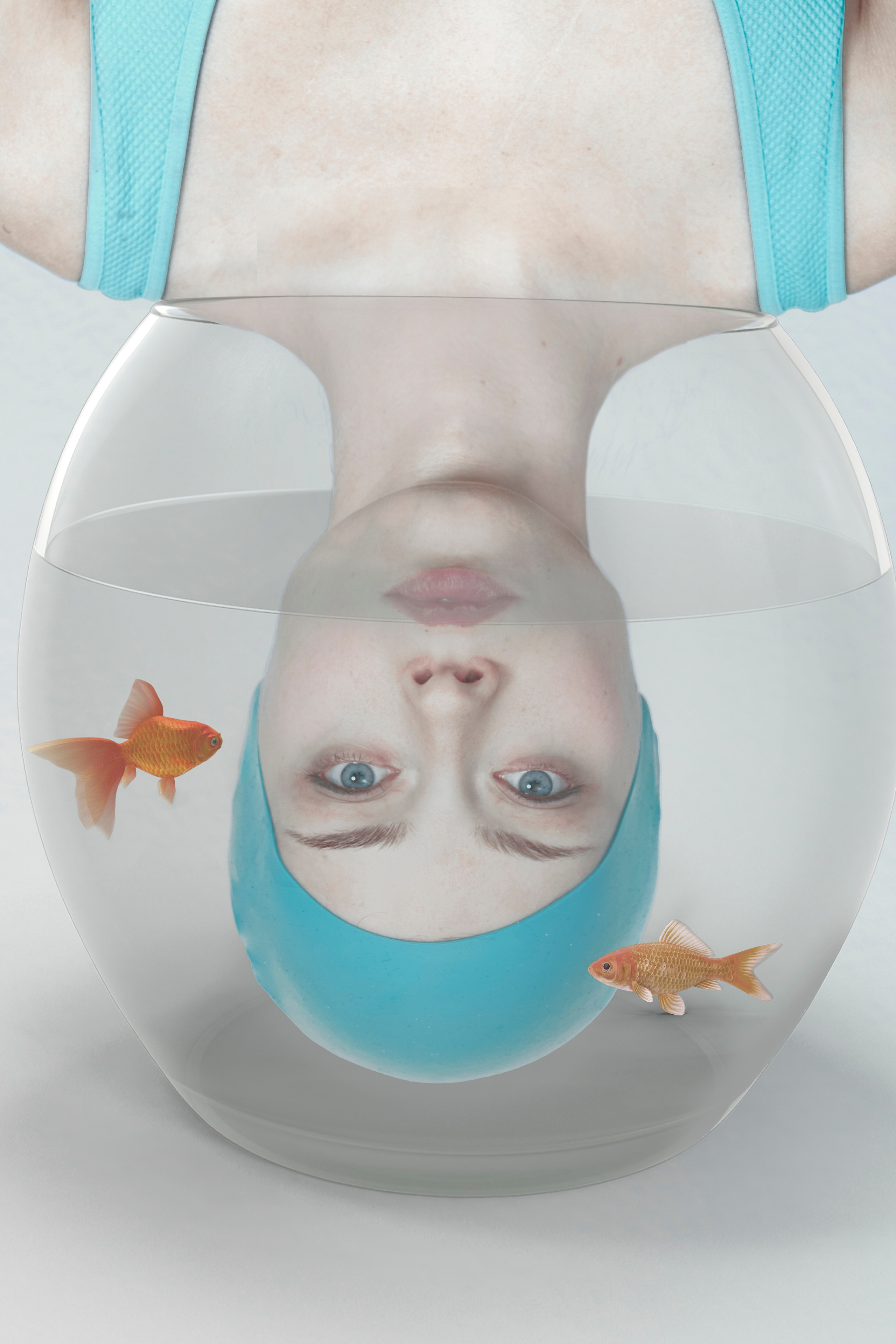 Upside-down reflection of woman in swim cap with goldfish, portraying isolation and transformation