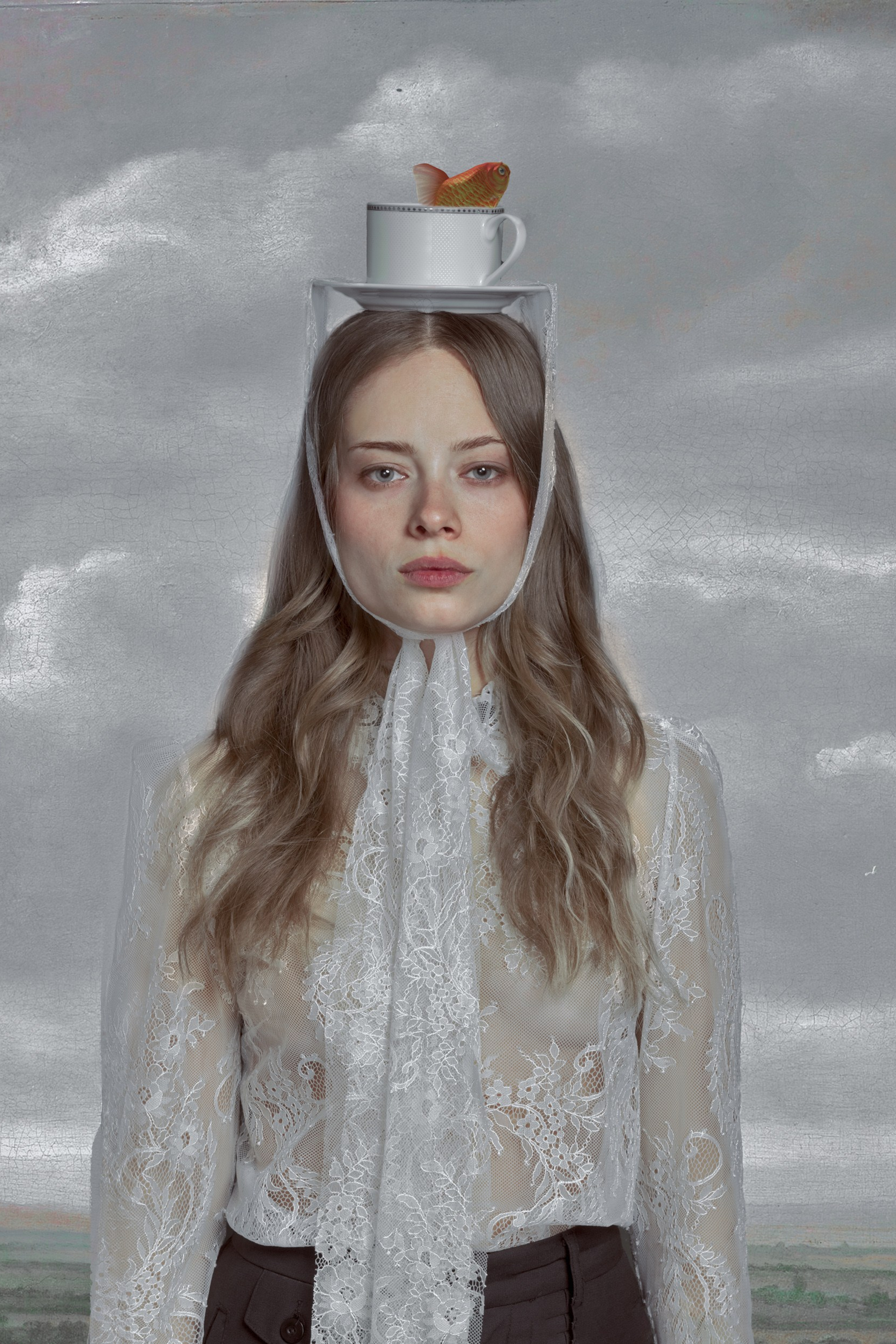 Woman with fishbowl headpiece symbolizes isolation in surreal portrait.