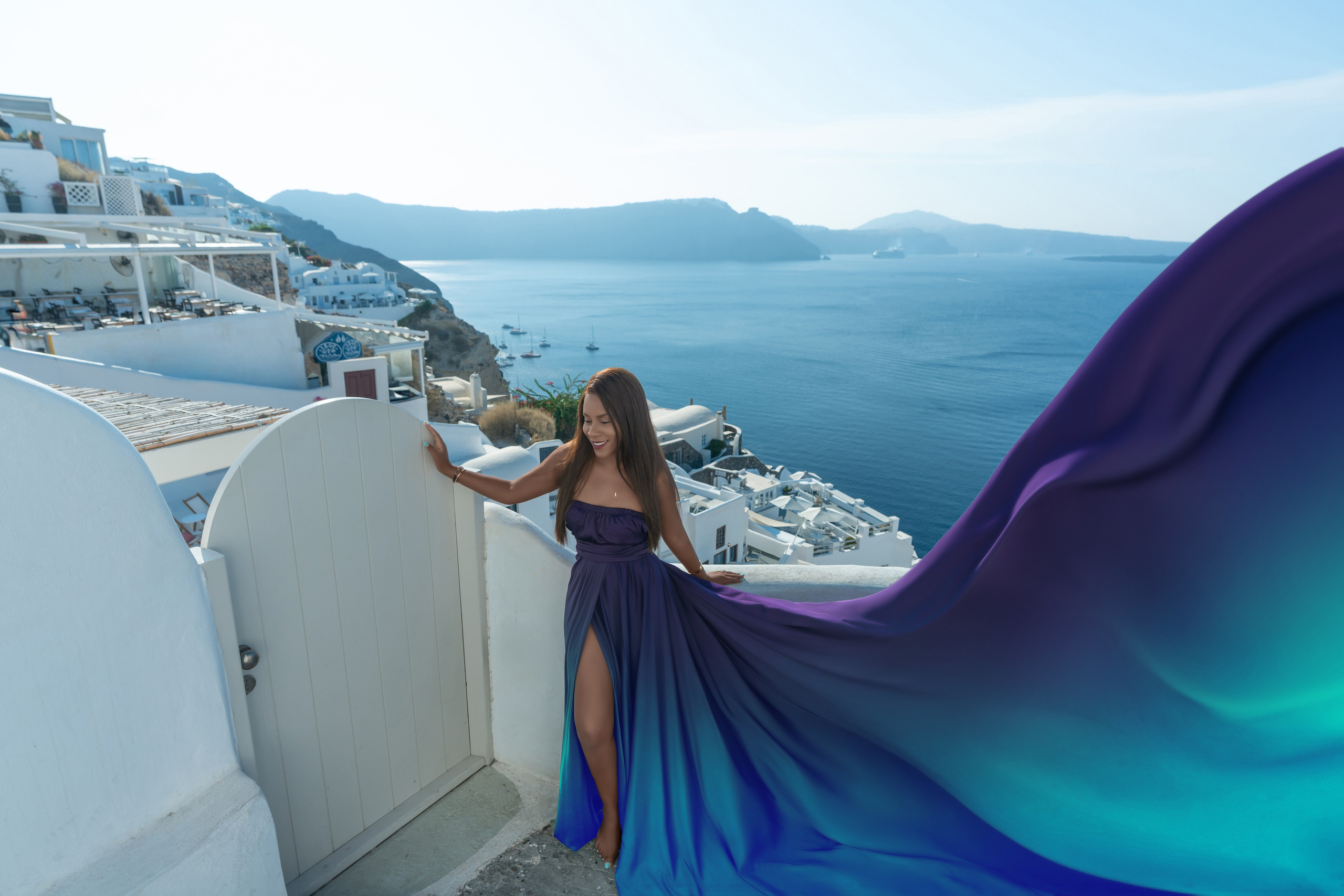 Grace and Glamour: A Couple’s Dream Photoshoot in Oia with a Violet Flying Dress