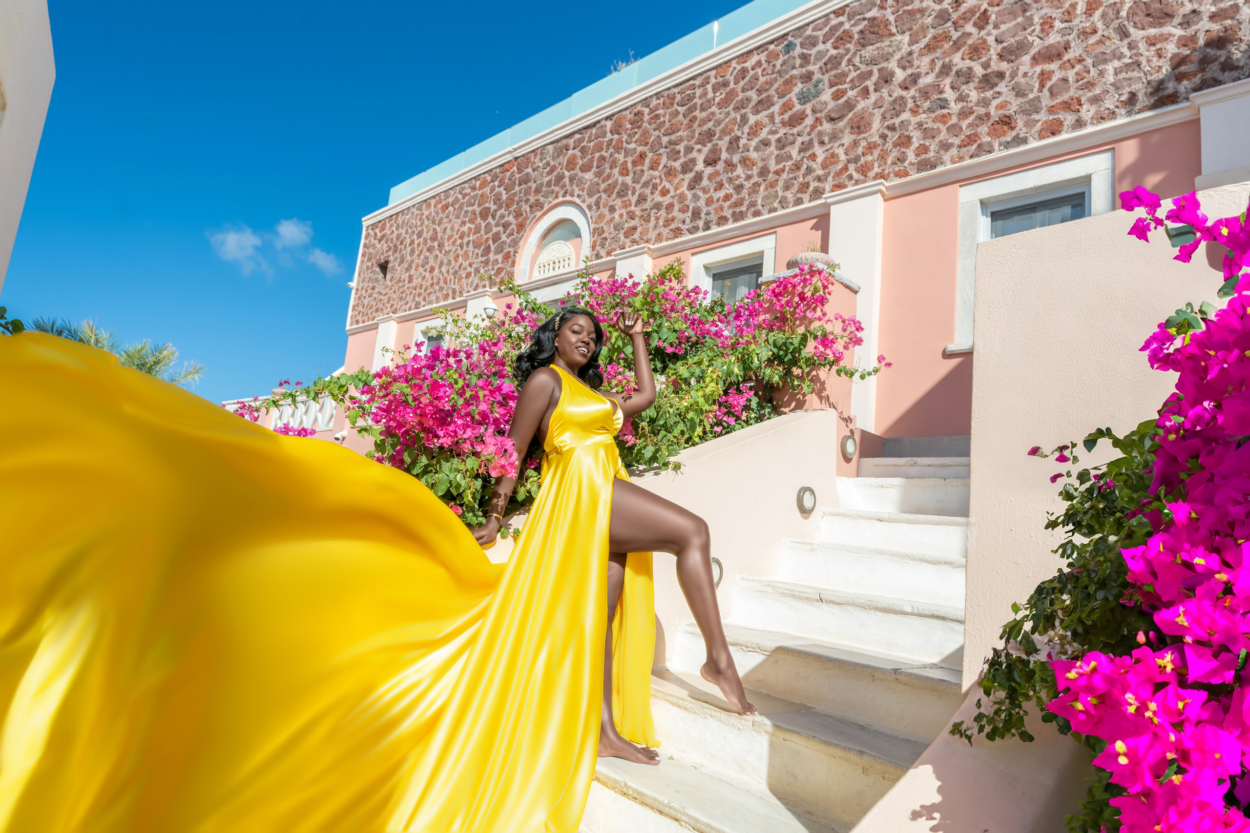 Golden Elegance in Santorini: Capture Breathtaking Moments in a Yellow Flying Dres