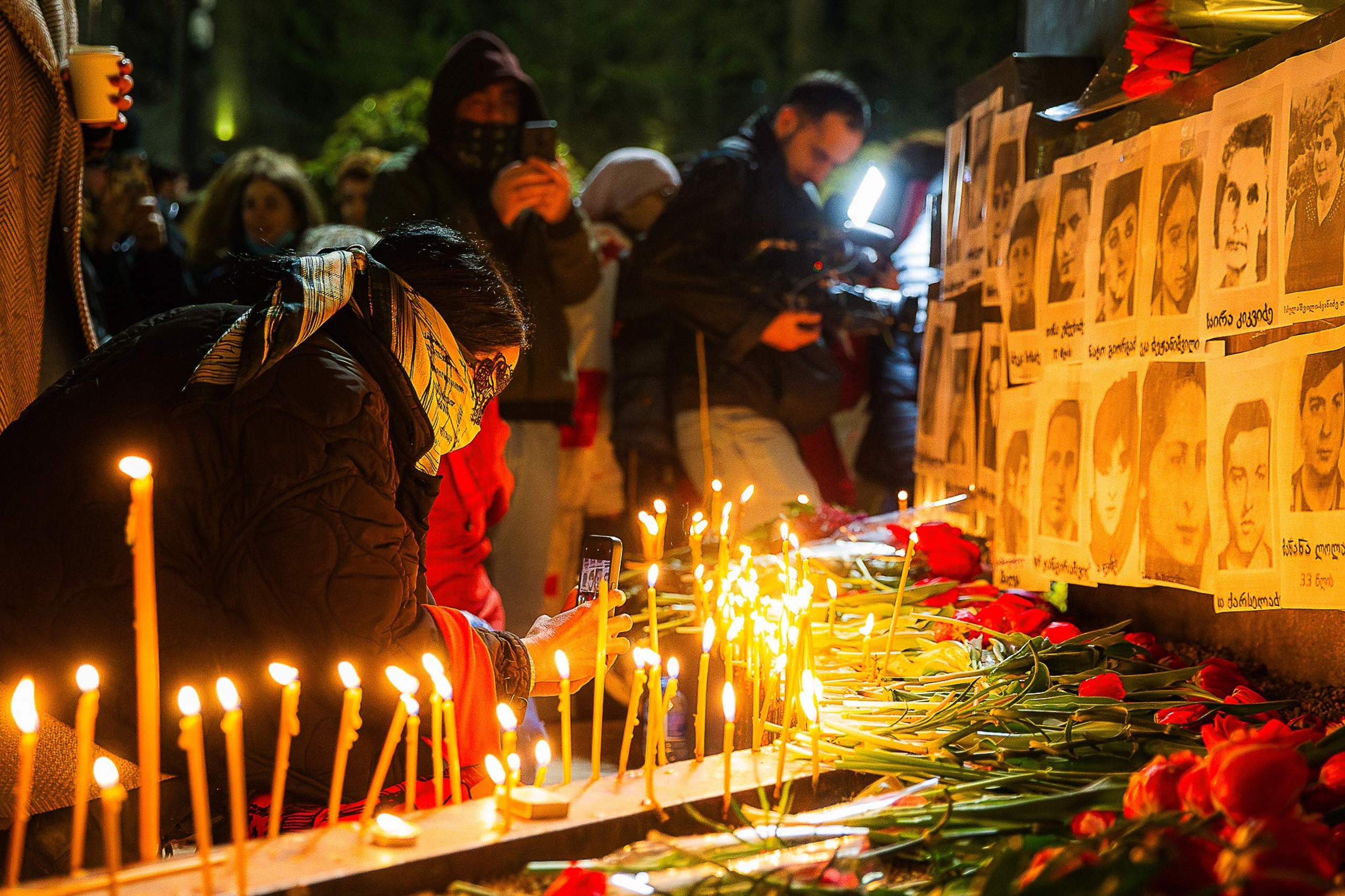 People with flowers and candles at April 9 memorial, Tbilisi 2025