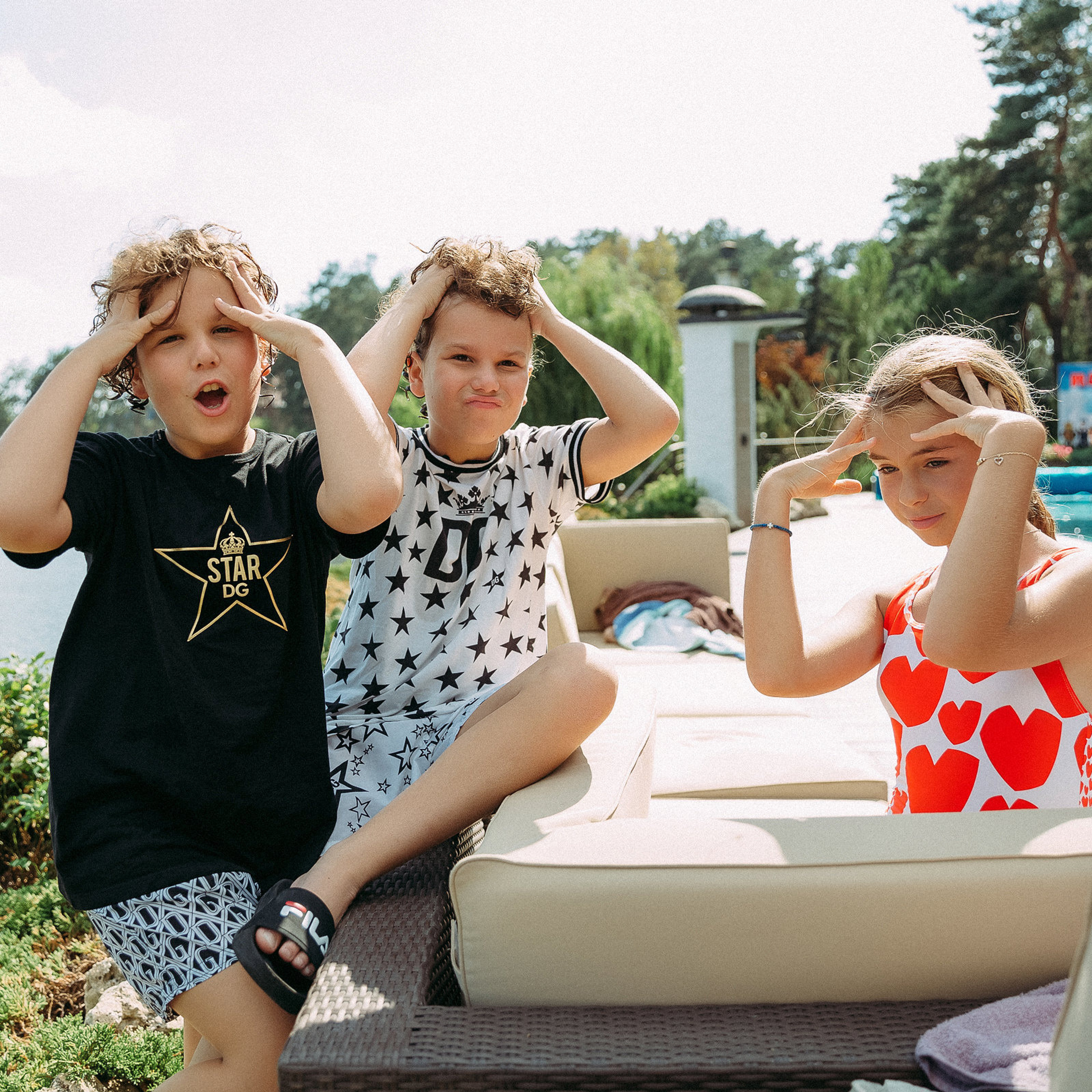 Дети на фоне реки держаться за голову.