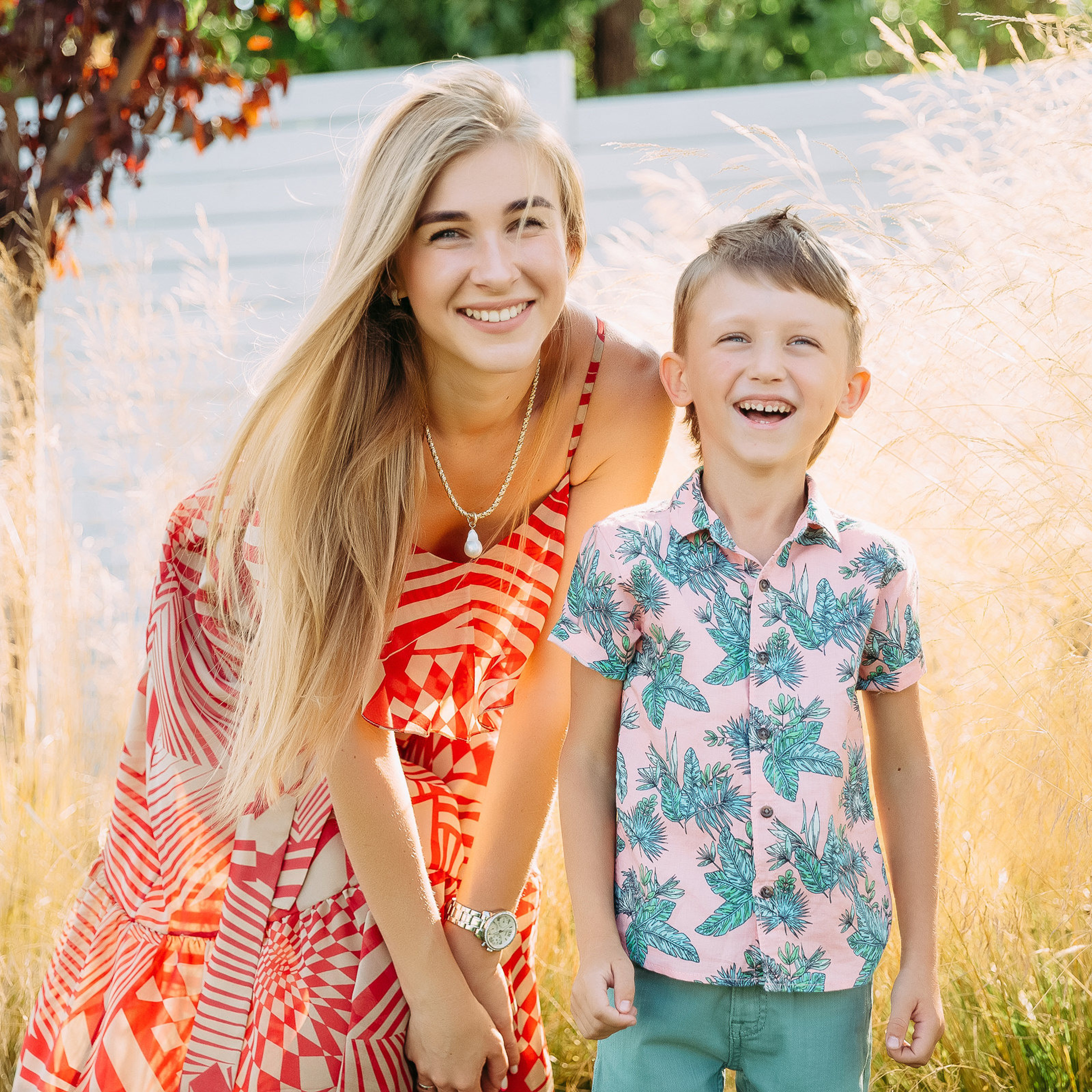 Фотография веселых матери и сына на дне рождения на теплом фоне.