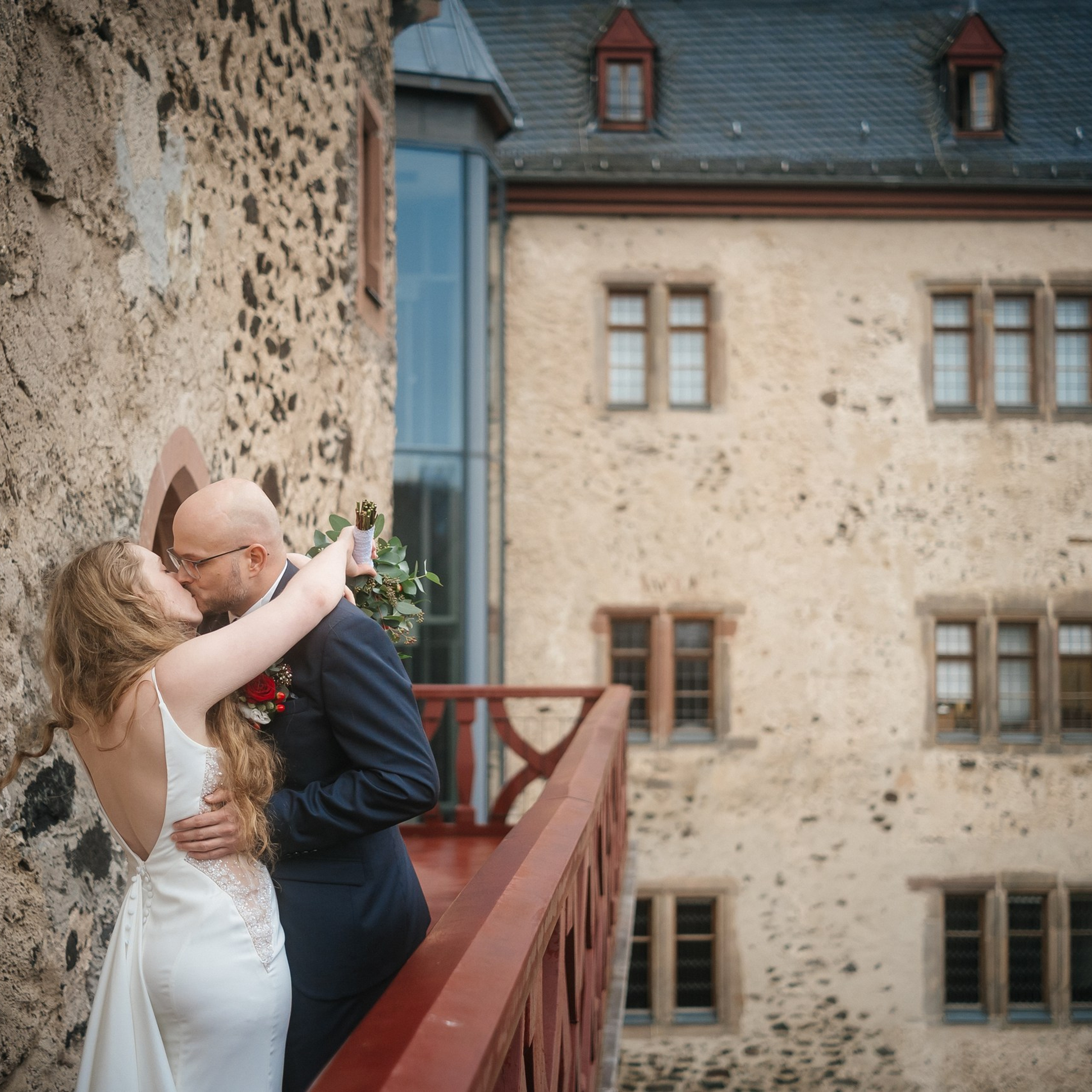 bride and groom kiss on the terrace