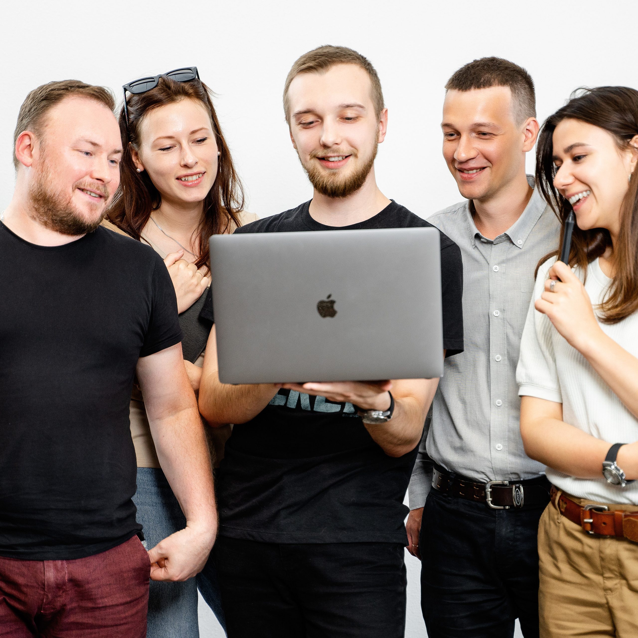Team of creative professionals sharing ideas on a laptop, laughing and brainstorming in a casual office environment, photo by Dmitrii Shmatov
