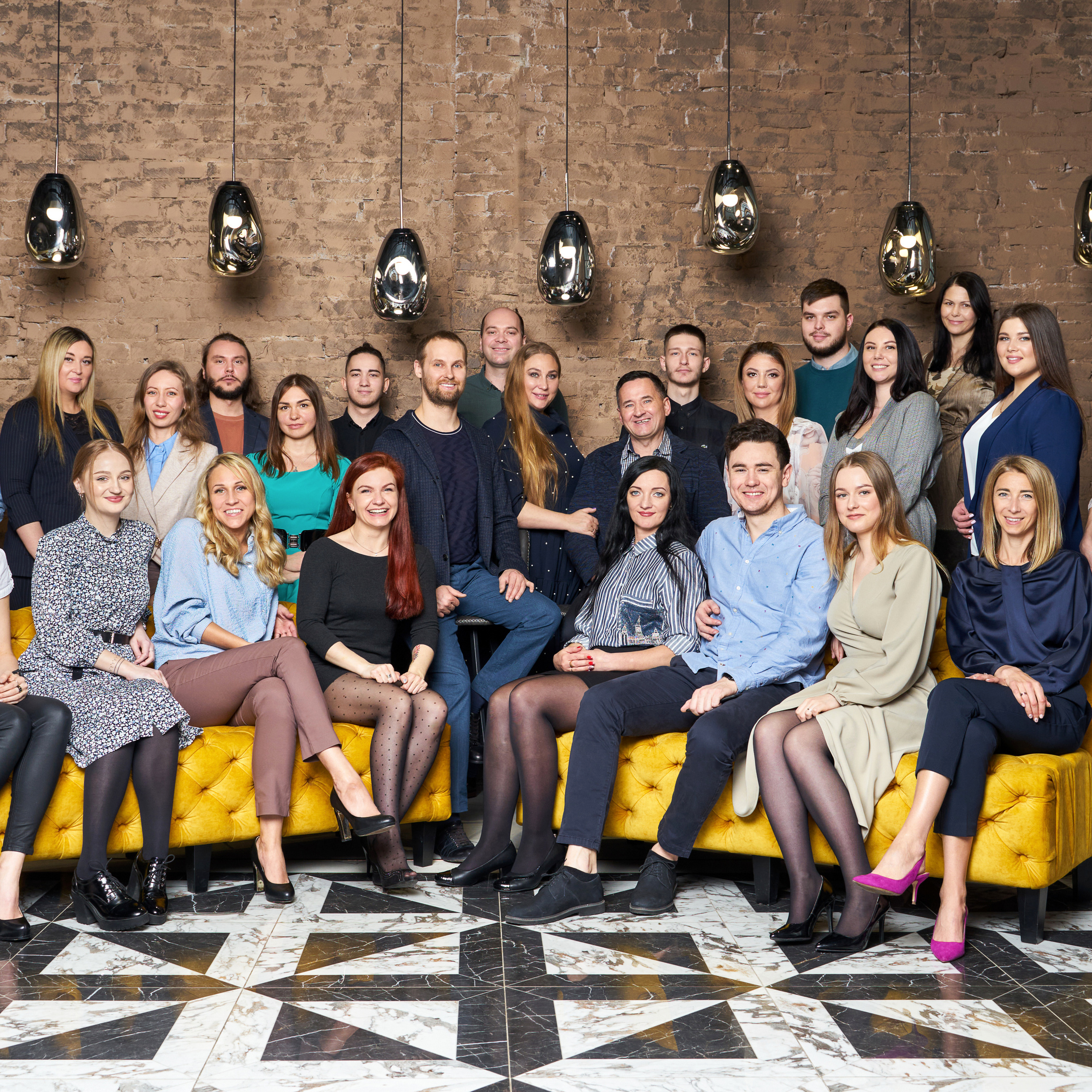 Corporate team portrait featuring a diverse group of professionals in a modern office setting, photographed by Dmitrii Shmatov