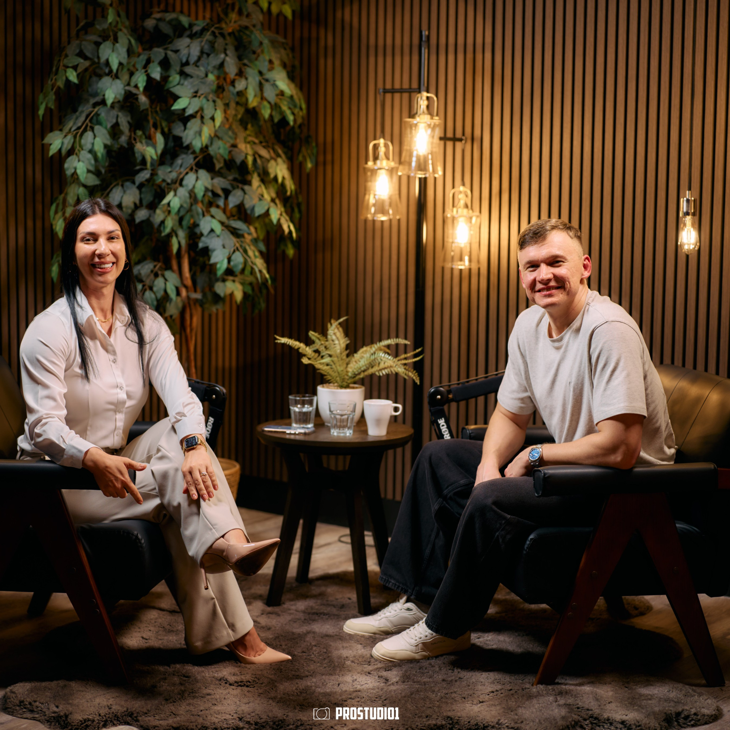 Two-person podcast interview filmed in Zone 2 Cinematic Lounge at ProStudio1 near Miami — a premium set in Hollywood, FL for YouTube and social content.