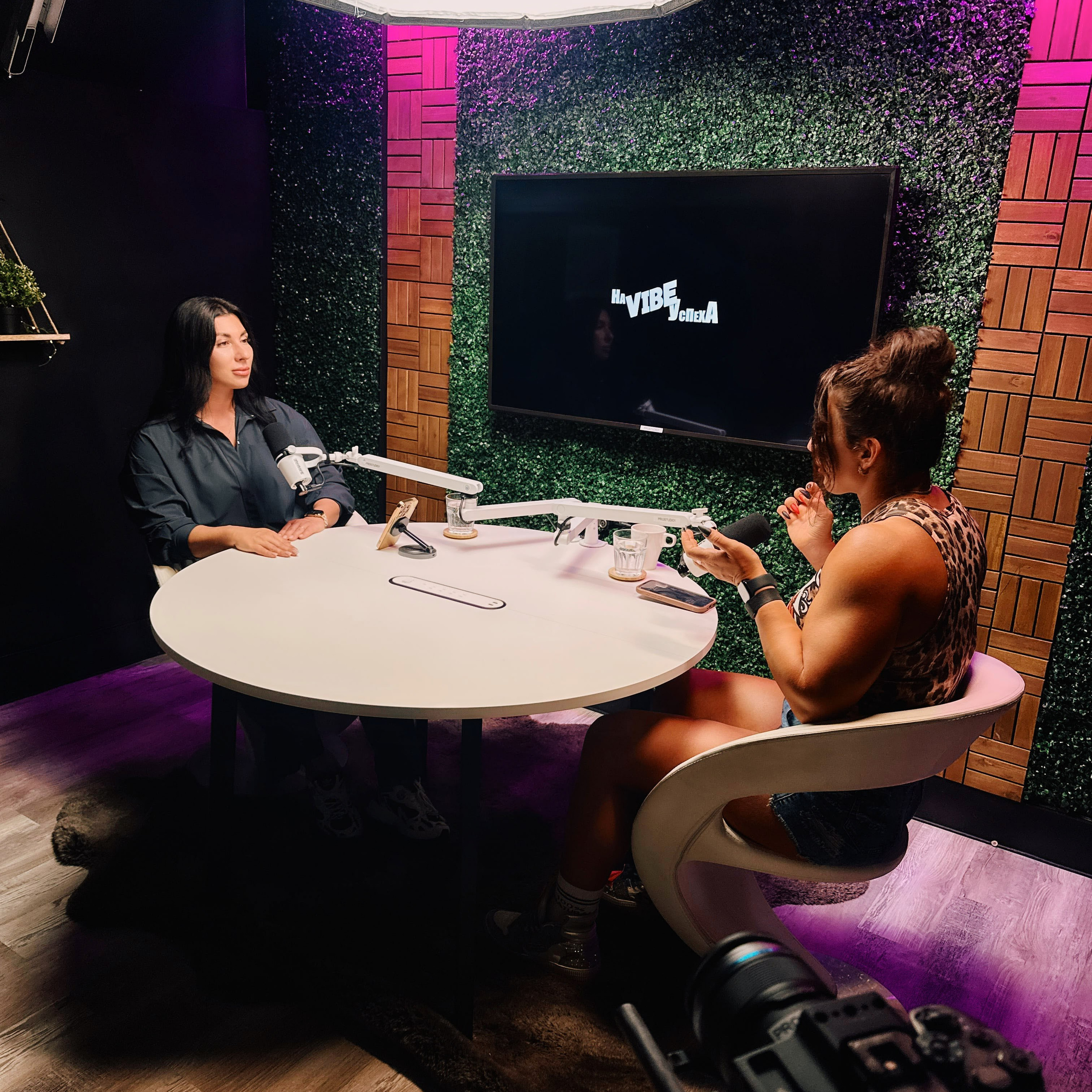Podcast guest speaking into studio microphone at ProStudio1, Hollywood Florida — close-up on talk-show set with moody lighting.