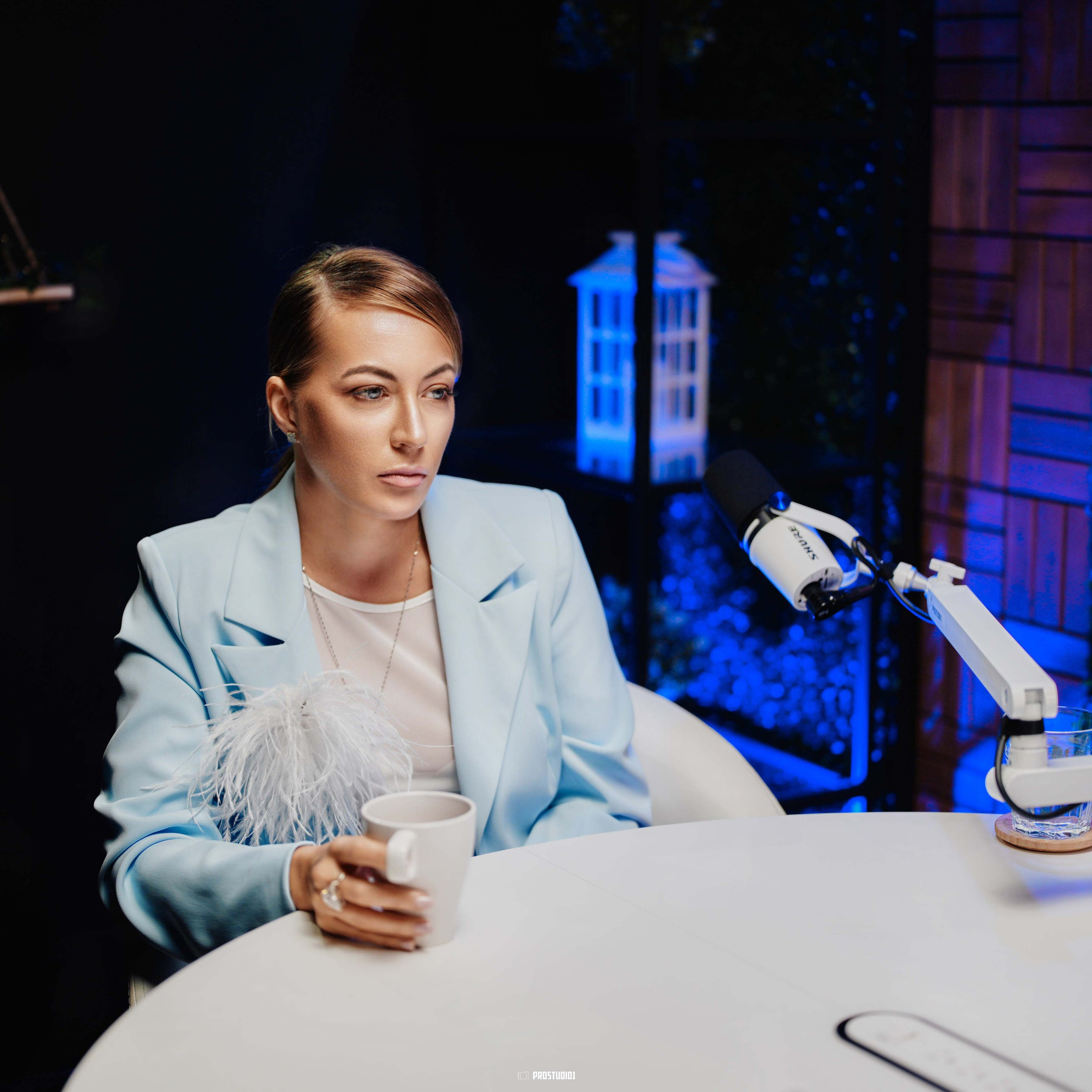 Cinematic podcast interview at ProStudio1, Hollywood Florida — talk-show table setup with professional audio gear and warm lighting.