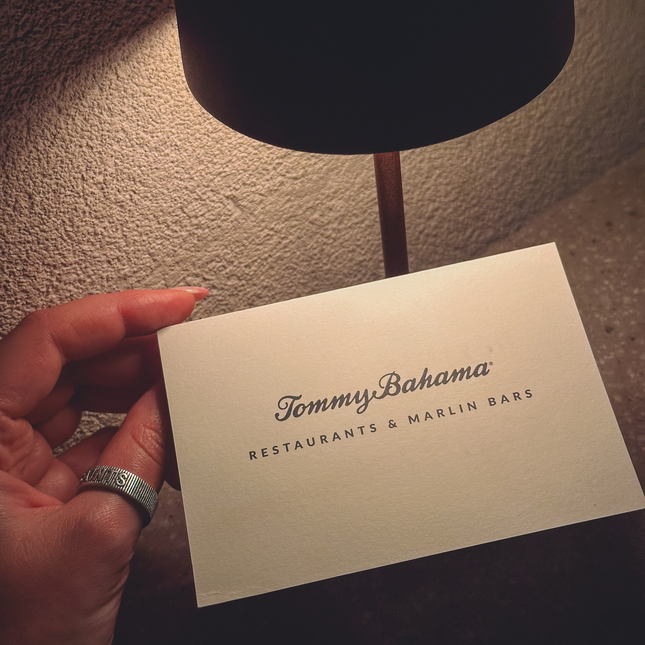 Tommy Bahama Restaurants & Marlin Bars card under warm lamp light