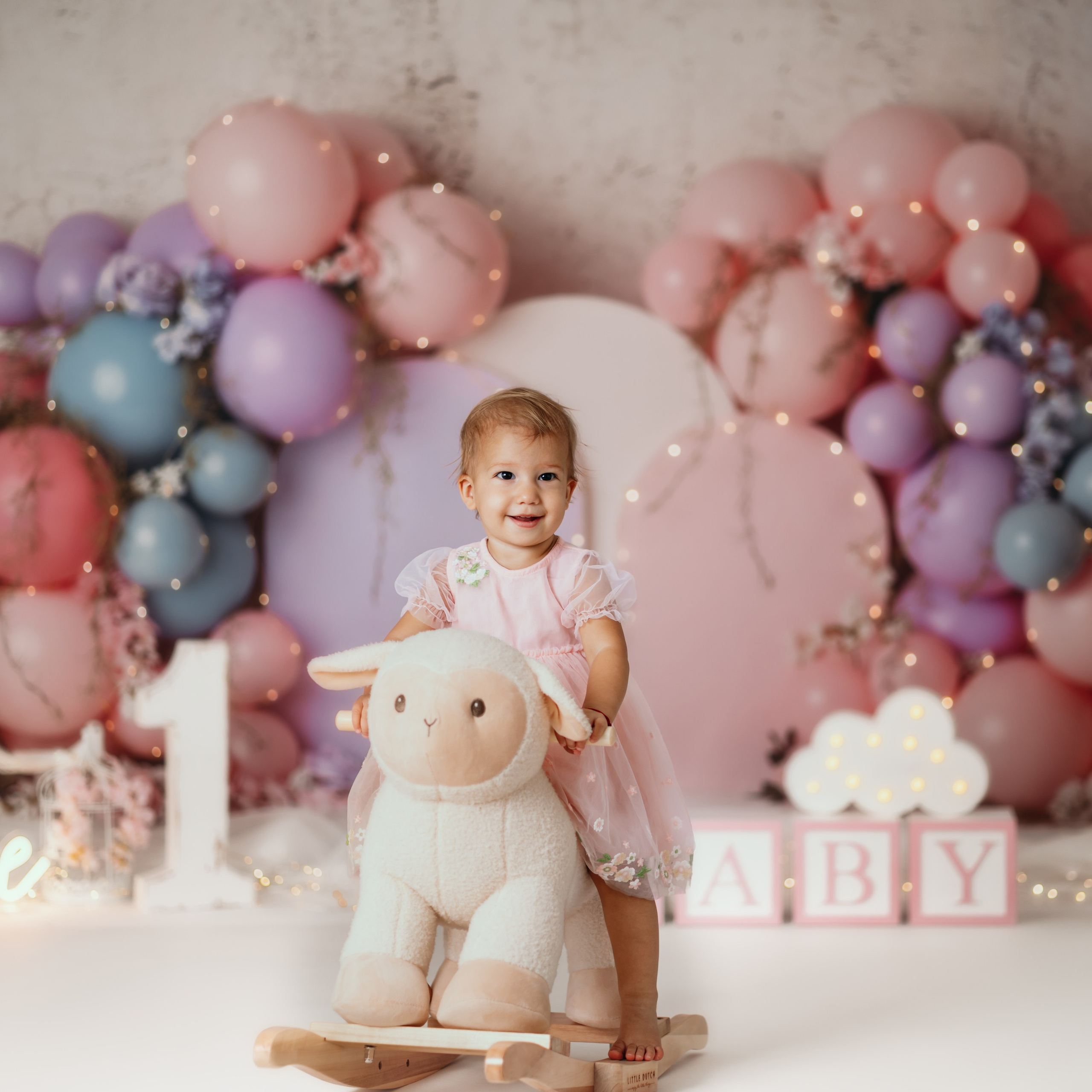 Fotografisanje prvog rođendana u pastelnoj temi sa lampicama i tortom