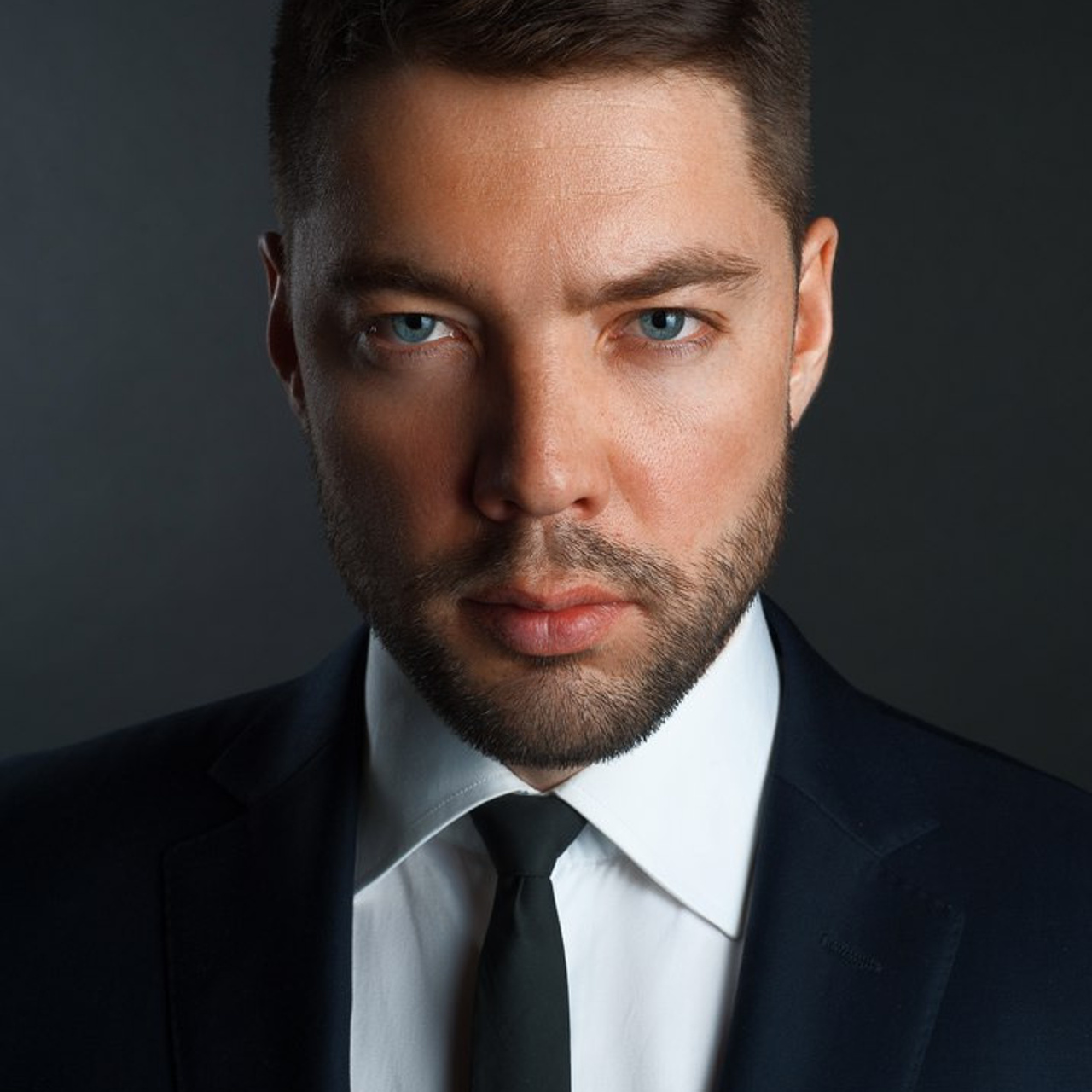 Sharp business headshot of a man in a dark suit and tie by Dmitrii Shmatov for professional networking.