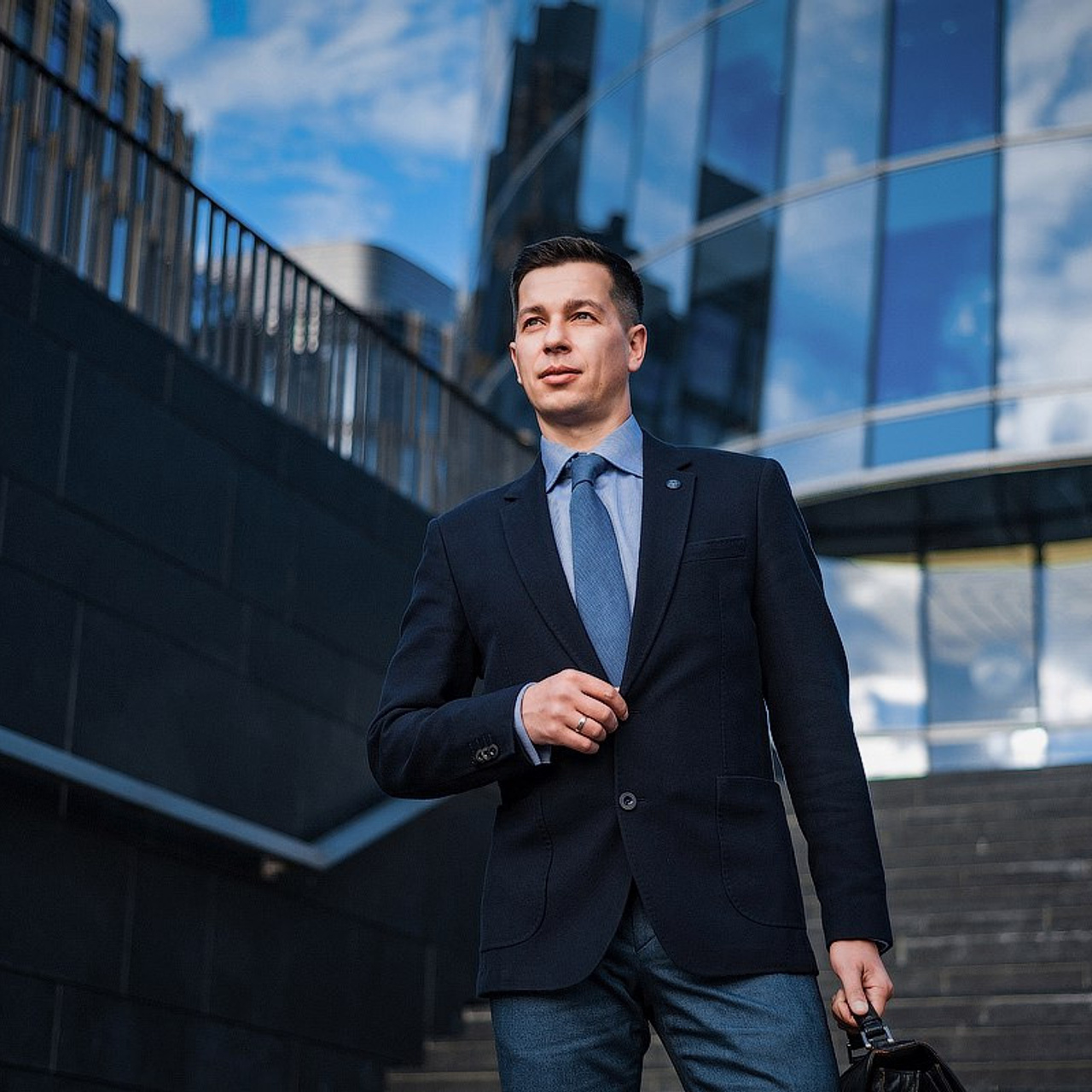 Smartly dressed businessman with a briefcase walking confidently in front of a modern glass building, business portrait by Dmitrii Shmatov