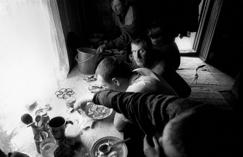 Рыбаки в своей хибаре во время еды. Посёлок Курбулик, Баргузинский район, Бурятия, Россия. Октябрь 2001