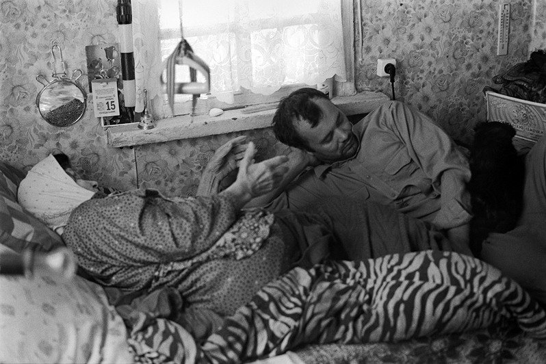 Grandson having worked on the farm lay down to rest and listen to the complaints of his beloved grandmother, Senshin khutor, Oblivsky district, Rostov-on-Don region, Russia. November 2010