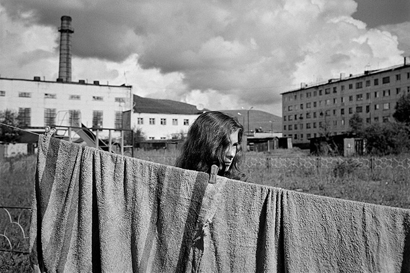 Girl hangs laundry for drying, Yagodnoye settlement, Magadan region, Russia. August 2014