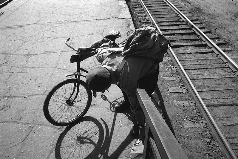 Cyclist on railway platform, Petushki, Vladimir region, Russia. May 1992