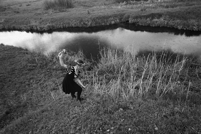 The girl collecting flowers on a river slope for weaving of wreaths, Senshin khutor, Oblivsky district, Rostov-on-Don region, Russia. May 2011