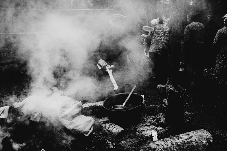 Марийский мужчина очищает свой топор огнем после завершения всех ритуалов, Республика Марий Эл, Россия. 2012