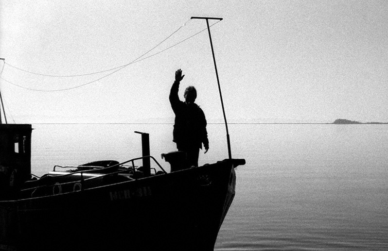 Силуэт рыбака на лодке. Мыс Покойники, Баргузинский район, Бурятия, Россия. Октябрь 2001
