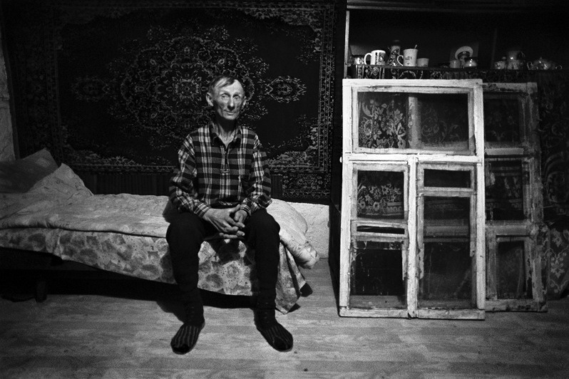 Portrait of Jurka Shutenko on the background of the carpet and remove the old windows, Senshin khutor, Oblivsky district, Rostov-on-Don region, Russia. November 2010