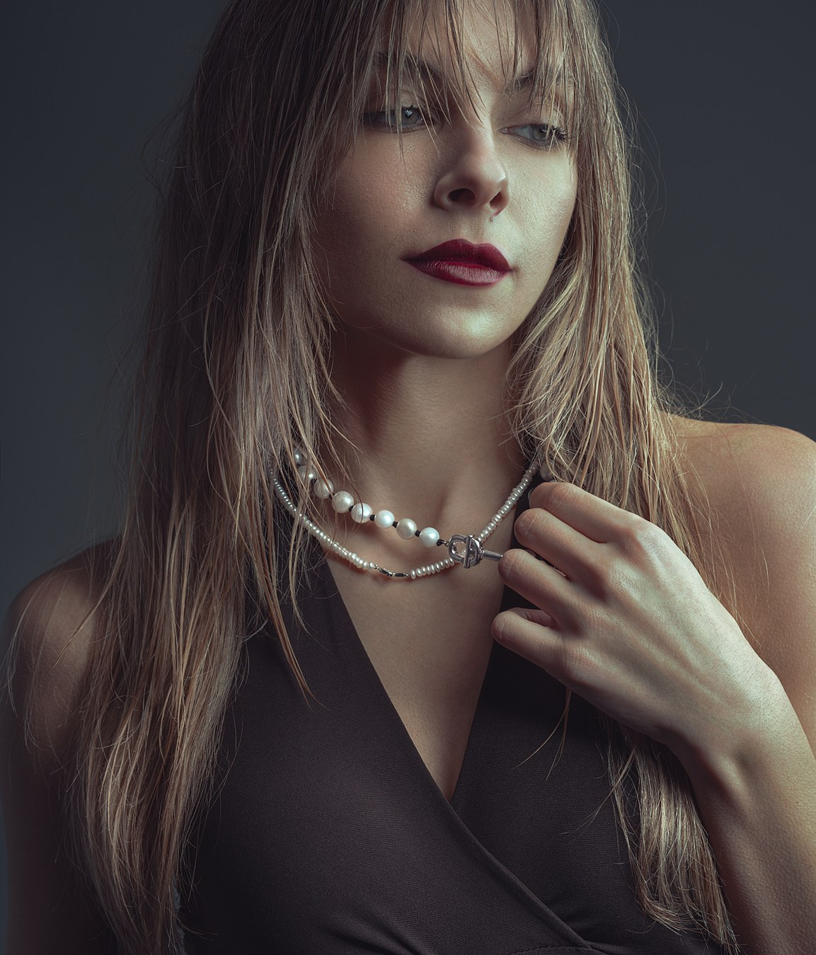 alt="modelka w minimalistycznej stylizacji prezentuje naszyjniki marki TOUS podczas sesji zdjęciowej"