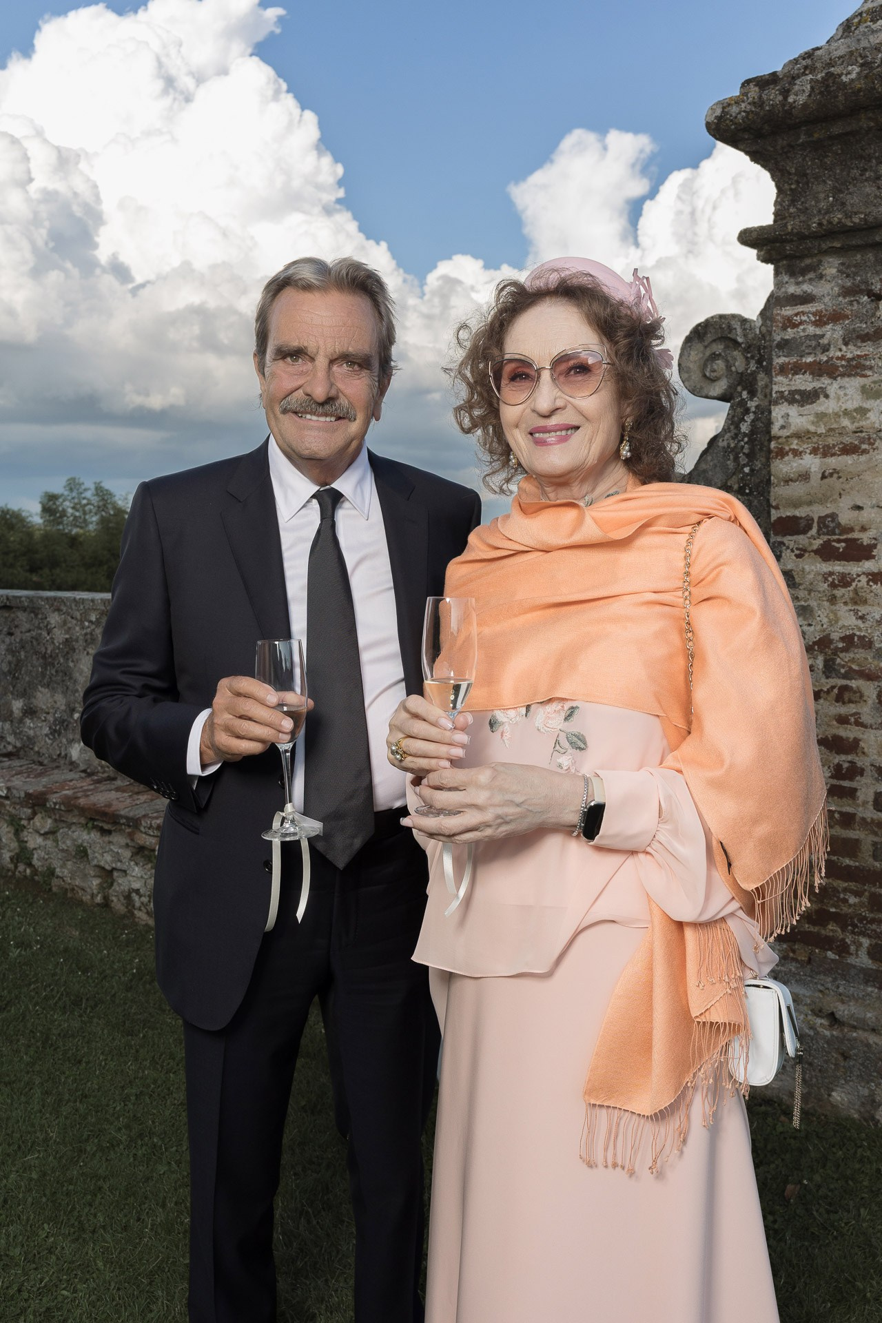 Sophisticated guest interaction at a luxury wedding or corporate gala in an Italian villa setting.