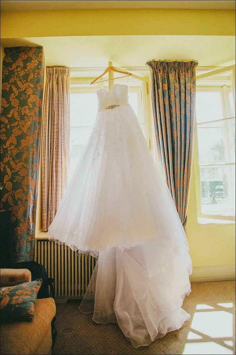 Bride’s wedding dress hanging by the window overlooking Vrtbovská Zahrada