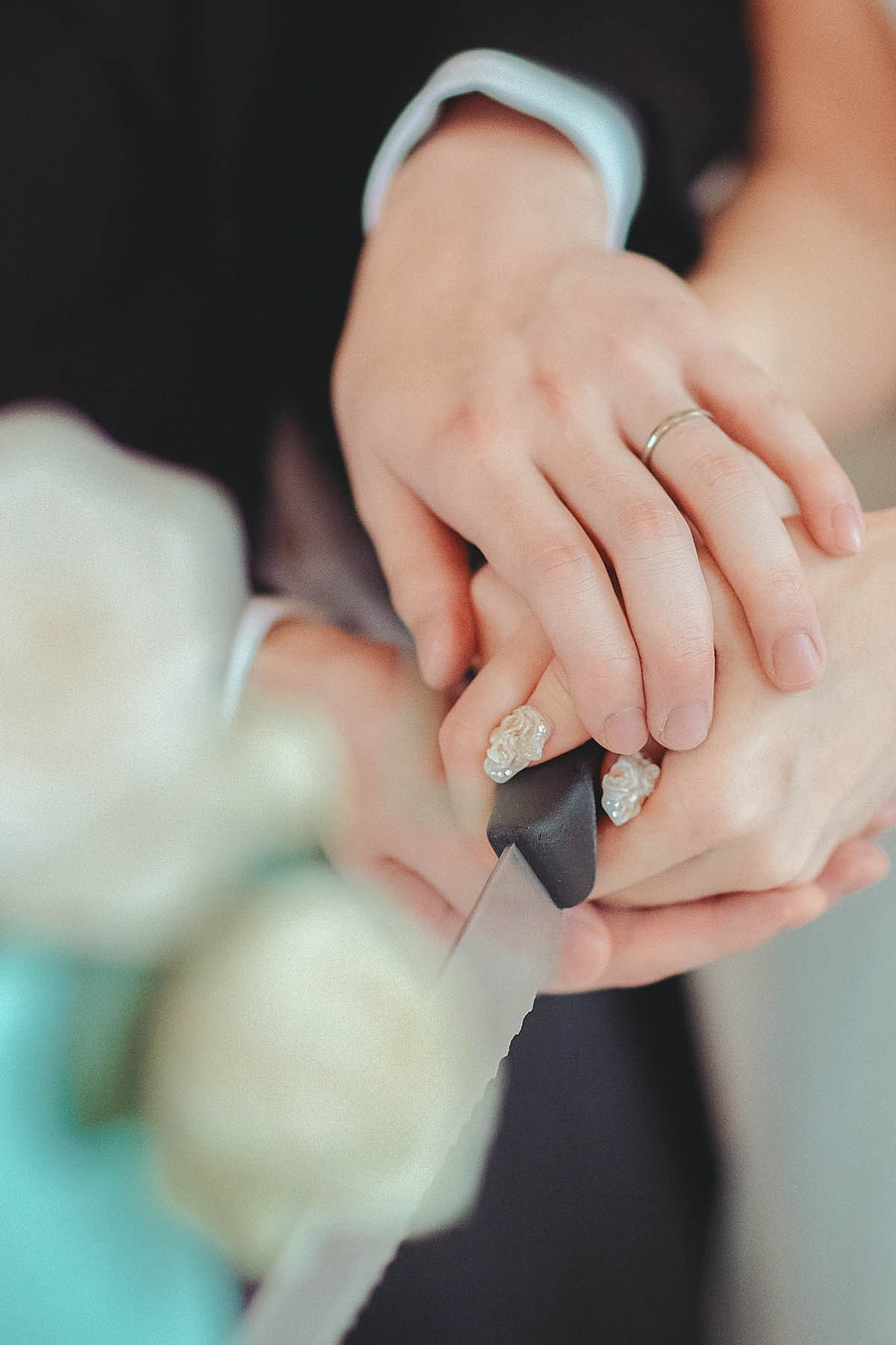 Close-up of the bride's nails during the cake cutting with the groom.
