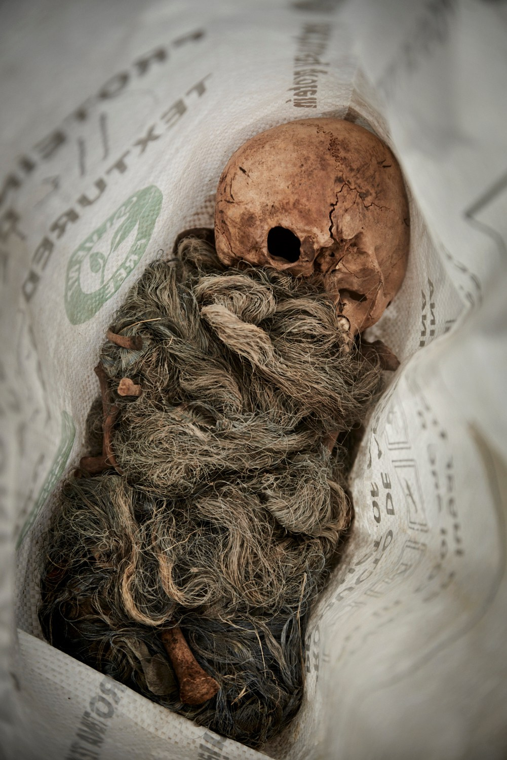 Gouvernorat de Damas, 22 décembre 2024 – Des ossements humains retrouvés dans la fosse commune du Pont de Bagdad, près de Damas. Un nom et un numéro sont griffonnés sur le sac contenant les os : Ali Khalifeh, n° 205. On estime à plusieurs milliers le nombre de corps enfouis dans ce charnier.